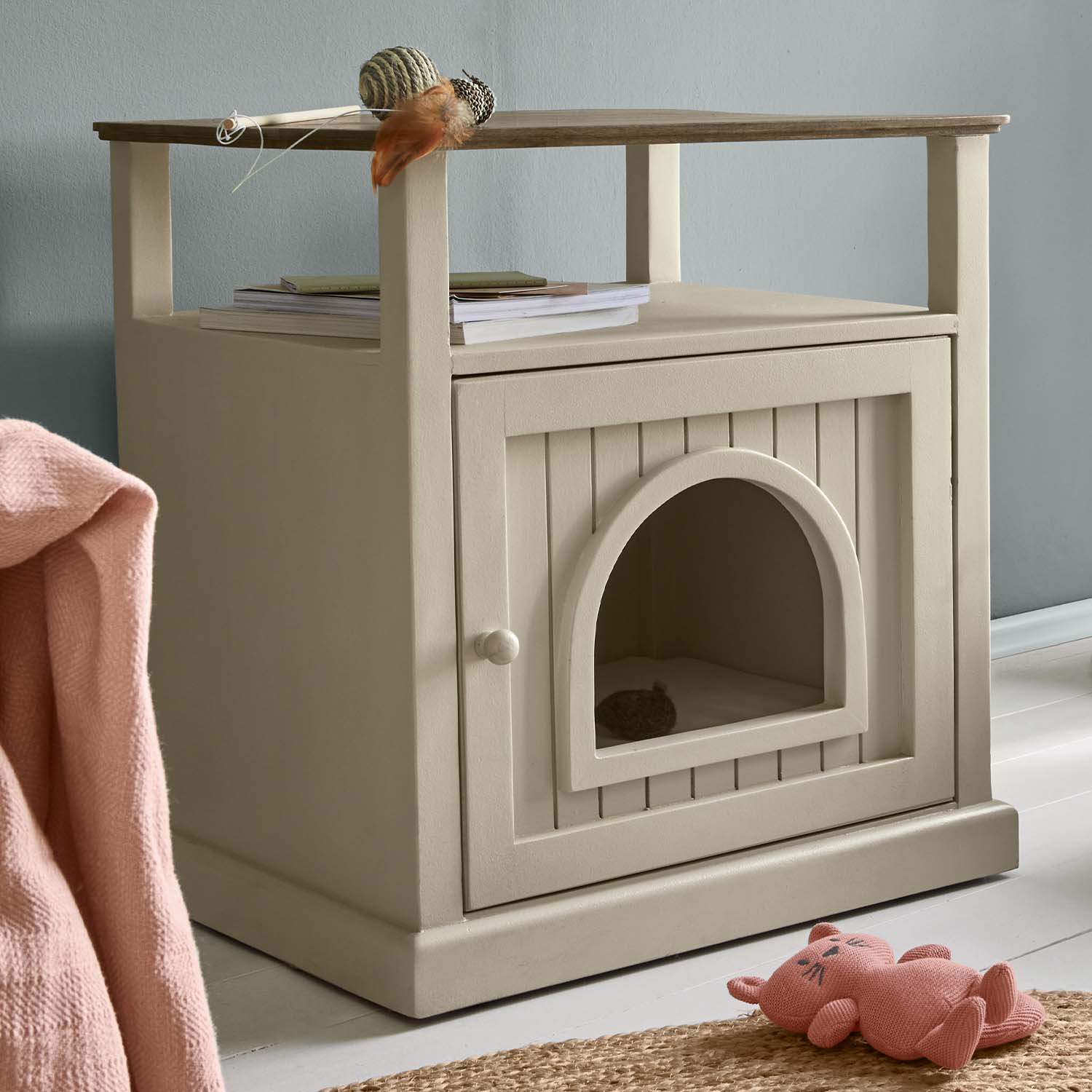 Meuble en bois beige avec ouverture en arc, combinant niche pour chat et table d'appoint pratique