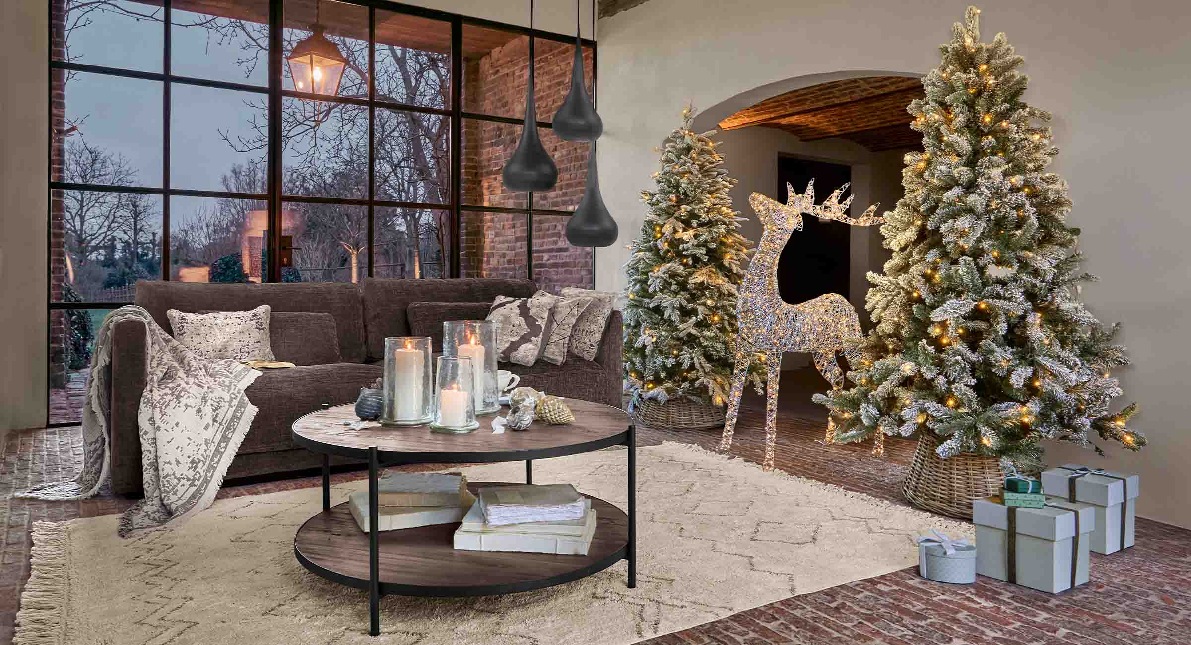 Salon chaleureux avec canapé marron, sapins de Noël illuminés et renne décoratif lumineux LED