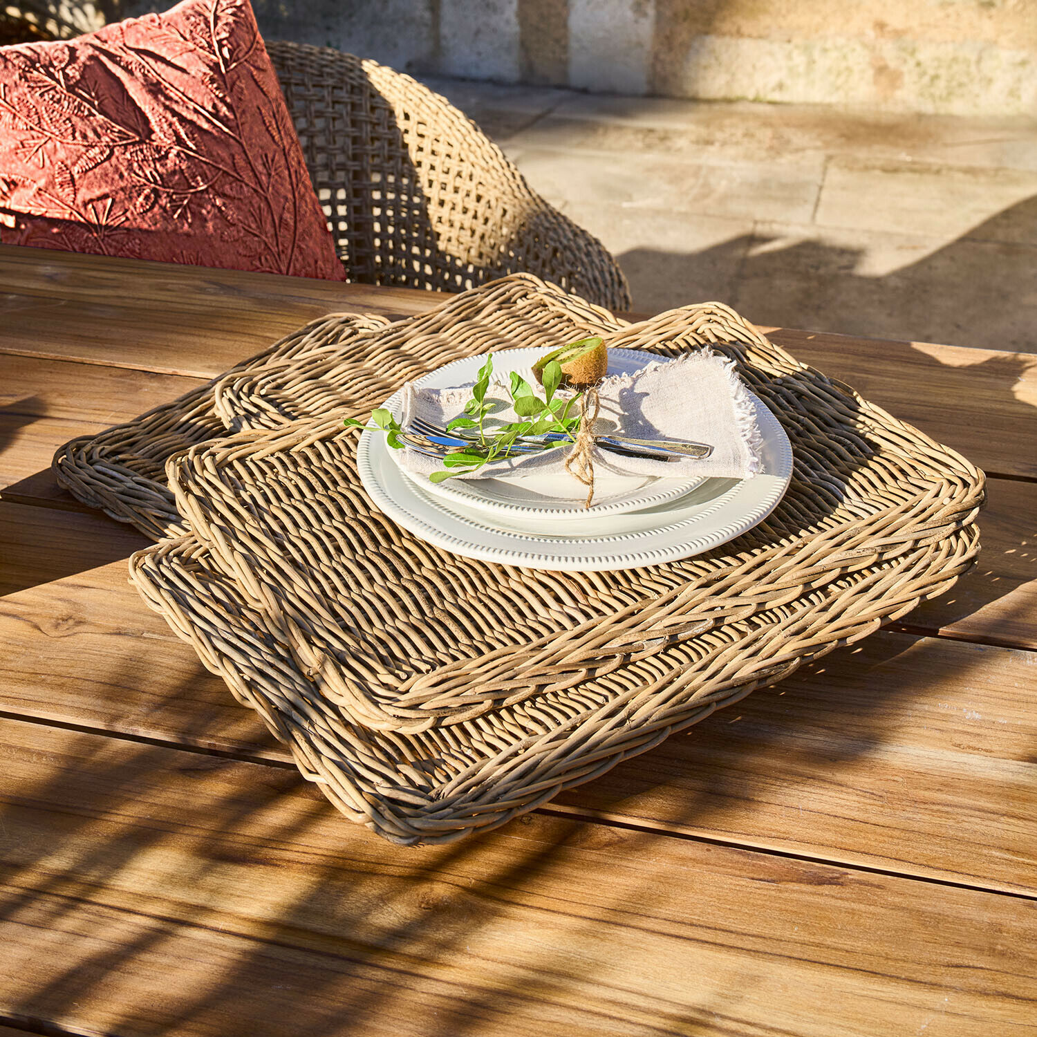 Ensemble de sets de table rectangulaires en osier naturel avec assiette blanche et couverts sur table en bois