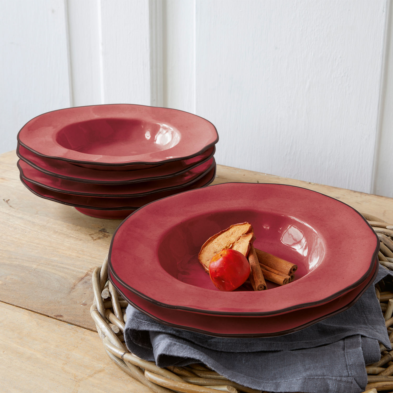 Lot de 6 assiettes creuses Biarré Ensemble d'assiettes creuses en céramique rouge posées sur une table en bois avec décoration d'épices