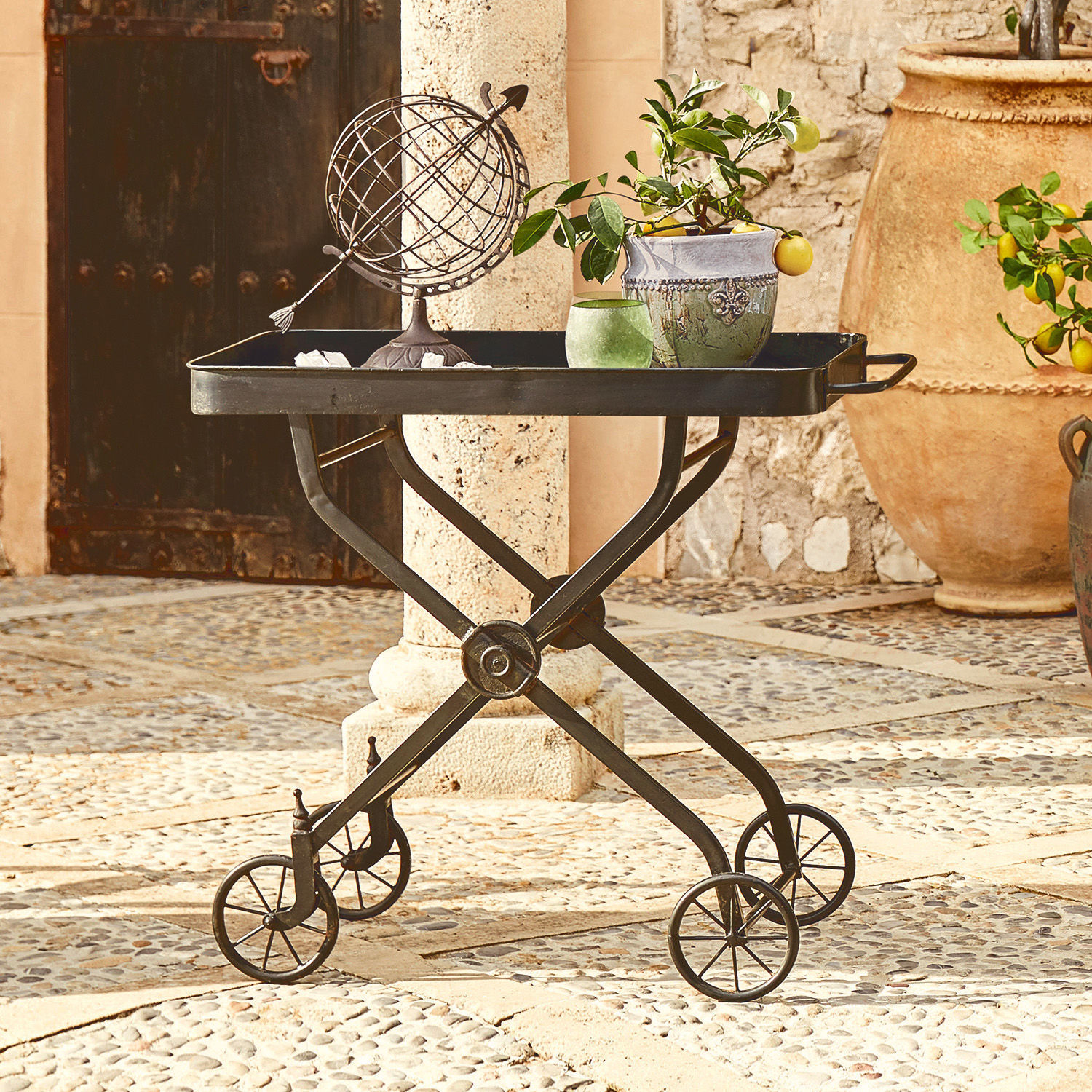Desserte Norfolk Table roulante en métal noir avec plateau, décorée d’un pot de fleurs et d’un globe vintage