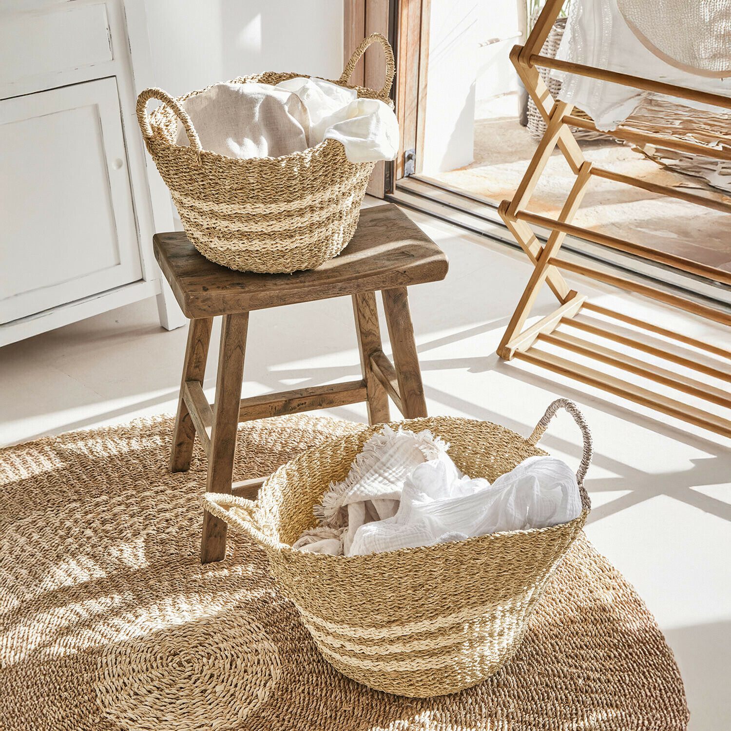 Lot de 2 paniers Farivon Paniers en herbe marine naturelle avec tissus blancs sur tapis rond dans une pièce lumineuse
