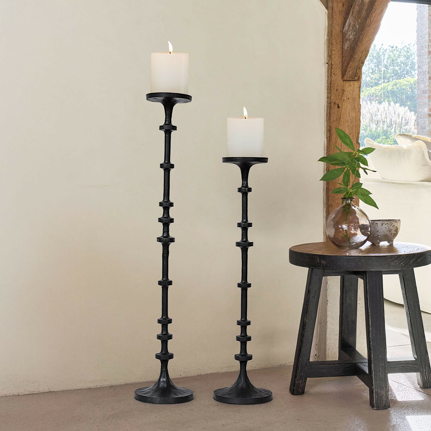 Lot de 2 bougeoirs Reville Ensemble de deux bougeoirs en métal noir avec bougies blanches, décoration intérieure lumineuse et naturelle