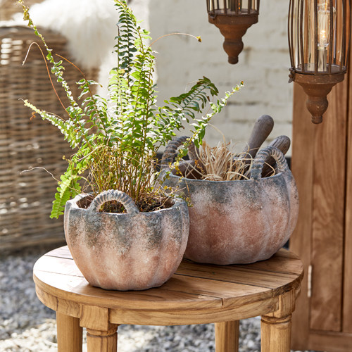 Deux pots en céramique en forme de citrouille sur une table en bois, décoration extérieure rustique