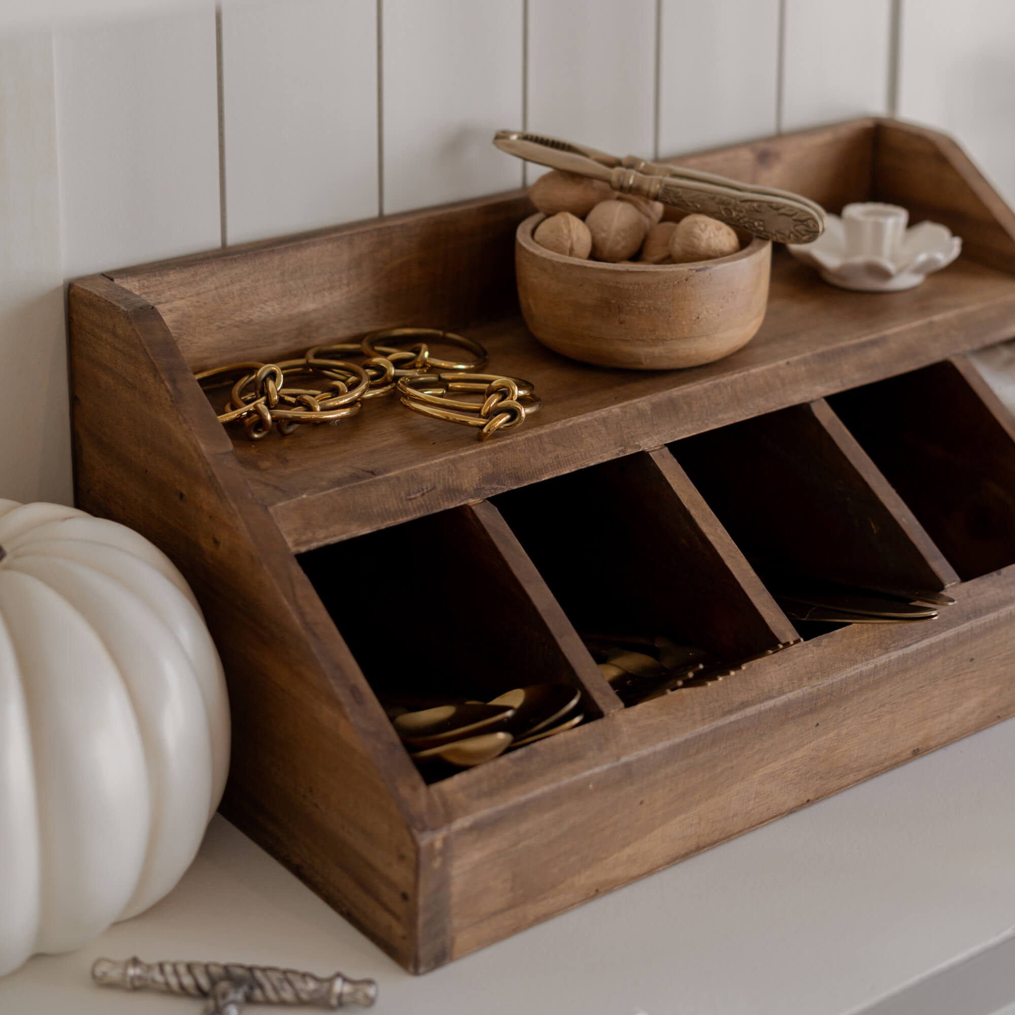 Organisateur en bois avec compartiments et bol en bois rempli de noix sur une surface claire pour ranger des petits objets