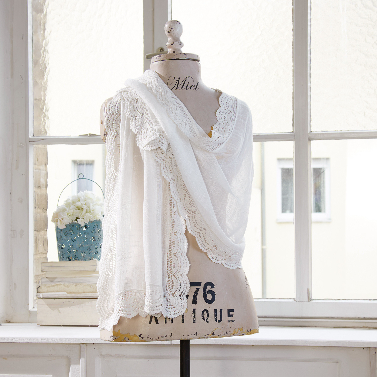 Étole Preciosa Étole blanche en tissu léger avec bordure en dentelle sur mannequin dans une pièce lumineuse
