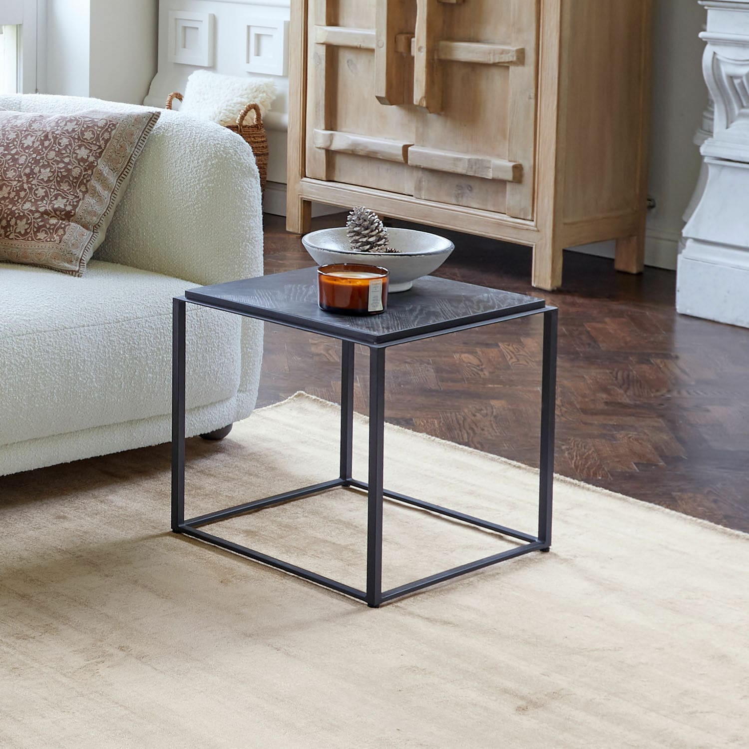 Table d’appoint Lumesto Table basse carrée en métal noir et bois dans un salon moderne avec tapis beige