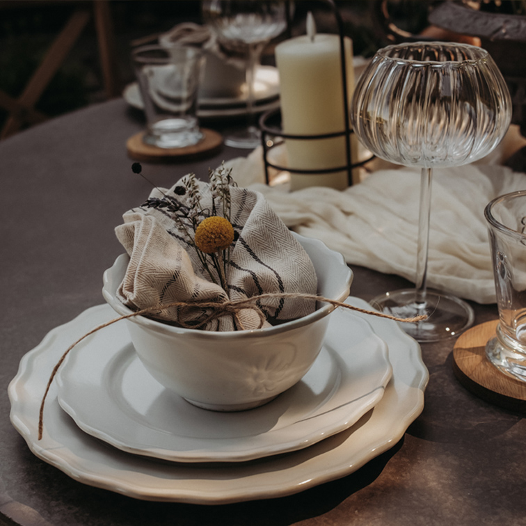 Ensemble de vaisselle en céramique blanche avec bol, assiettes et serviette en lin décorée de fleurs sur table