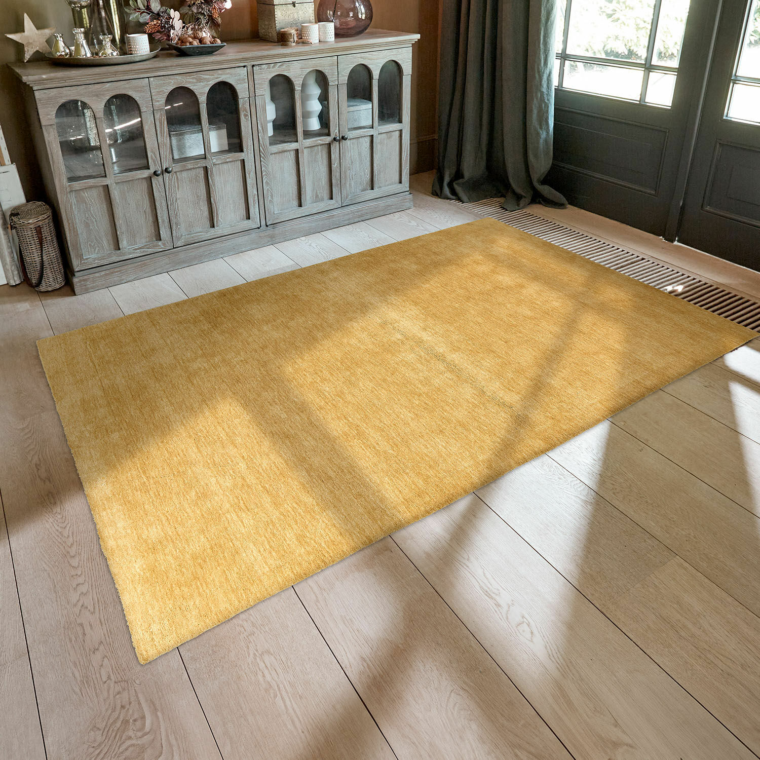 Tapis Cresil Tapis jaune uni en tissu doux sur un sol en bois clair dans un salon lumineux