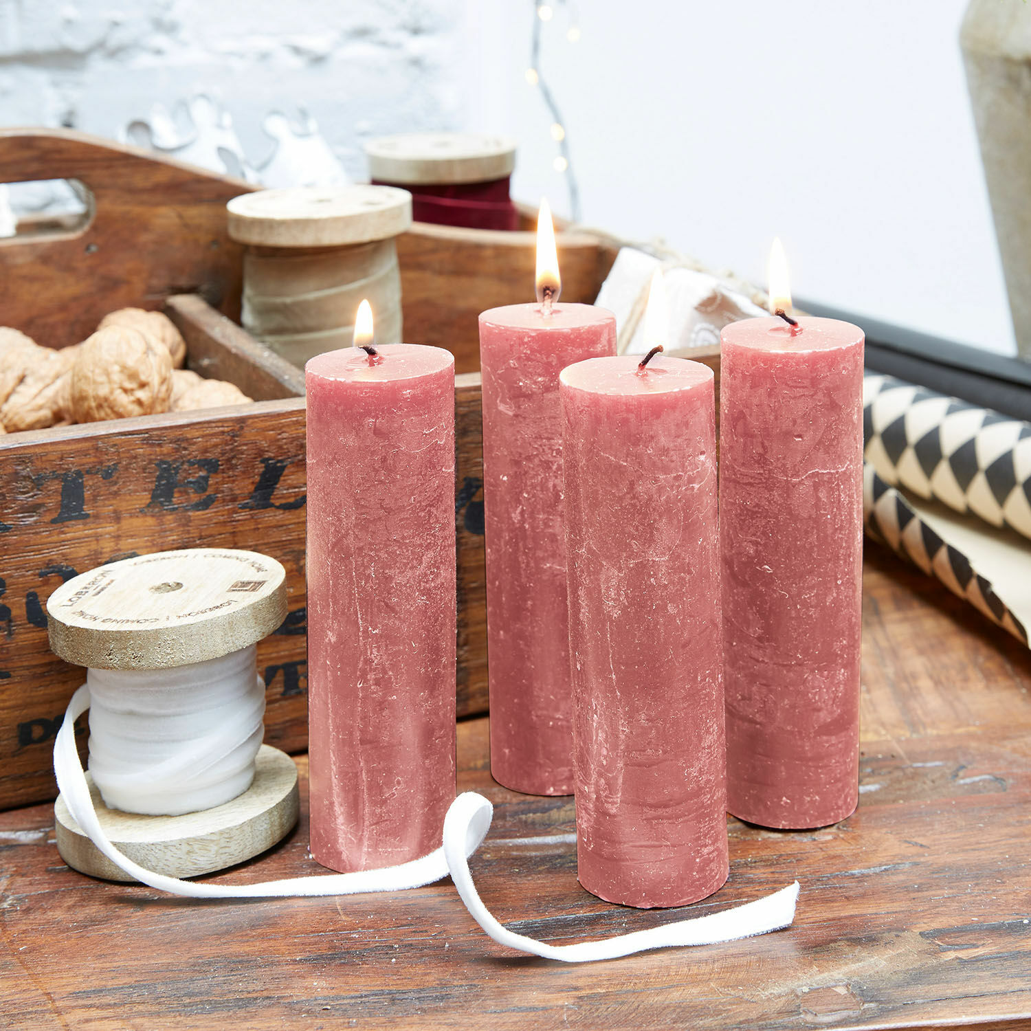 Lot de 4 bougies Muriel Quatre bougies roses en cire sur une table en bois avec ruban décoratif et noix