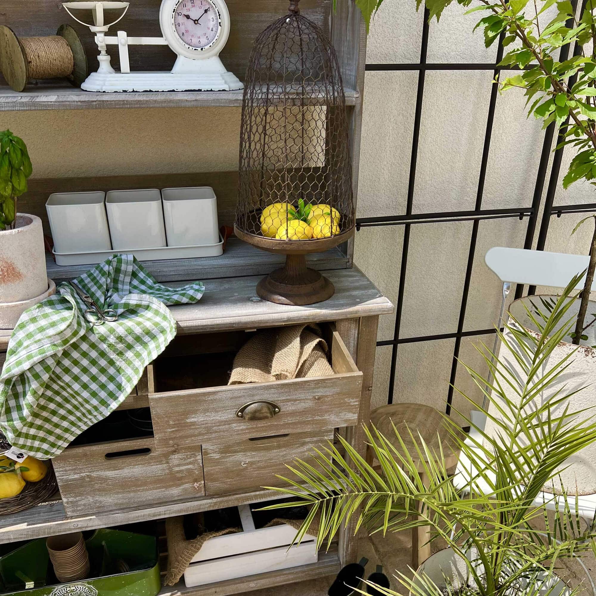 Meuble en bois rustique avec cage en métal et citrons, décoration de jardin naturelle