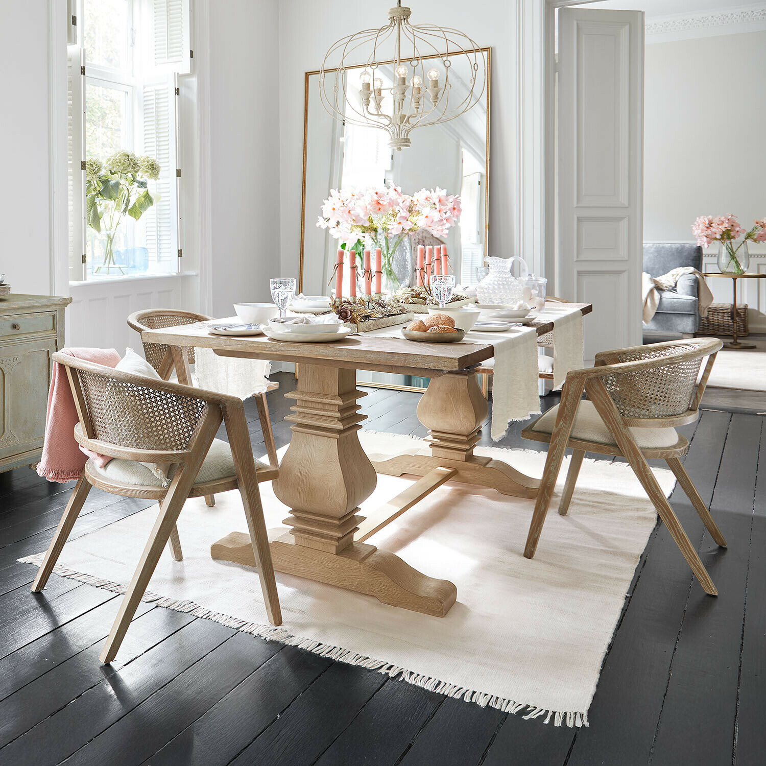 Table Cain Table à manger en bois clair avec chaises en rotin et décoration florale dans une salle à manger moderne