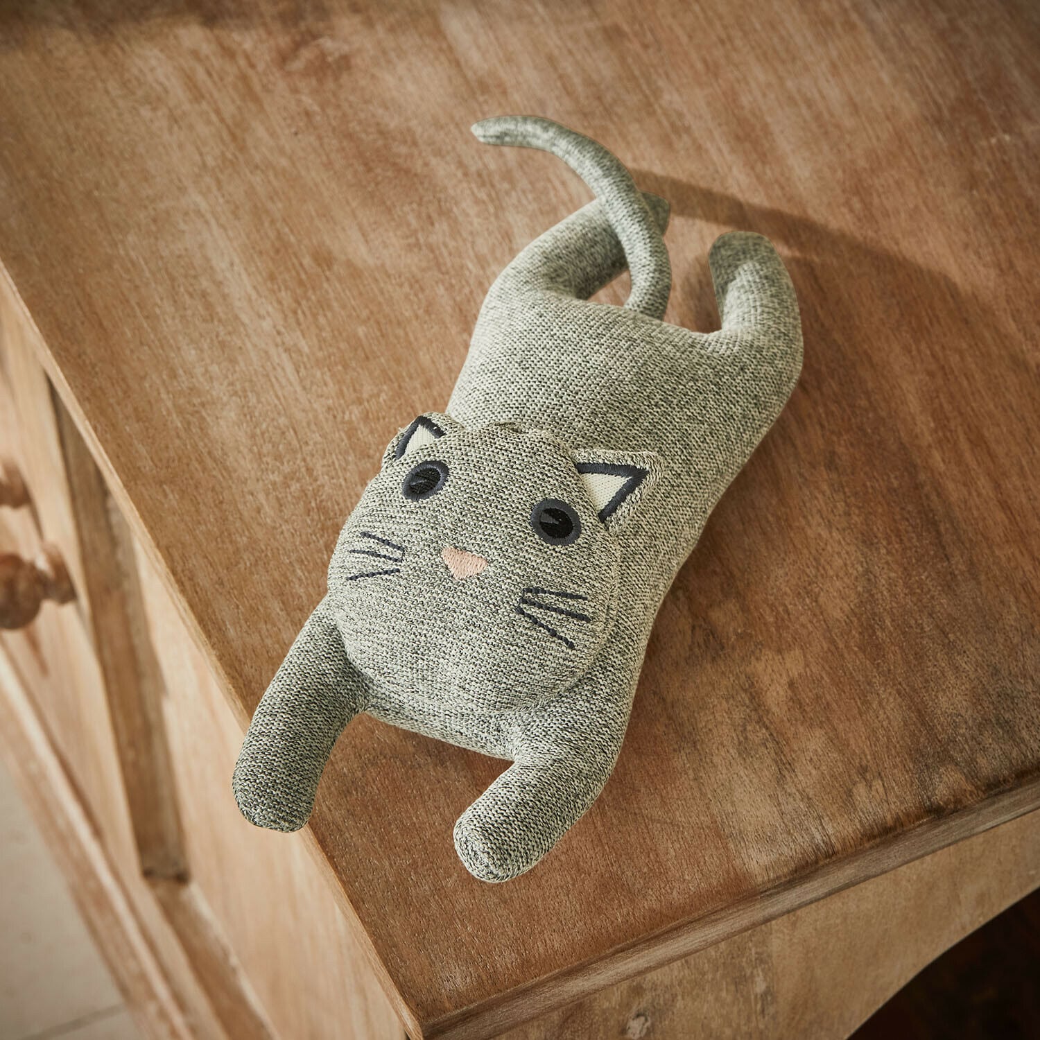 Jouet pour animaux Nalori Chat en tissu gris posé sur un meuble en bois, décoration intérieure et jouet doux