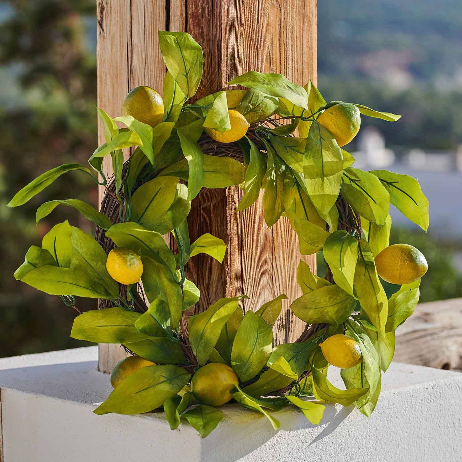 Couronne décorative avec citrons jaunes et feuilles vertes sur fond en bois, décoration estivale