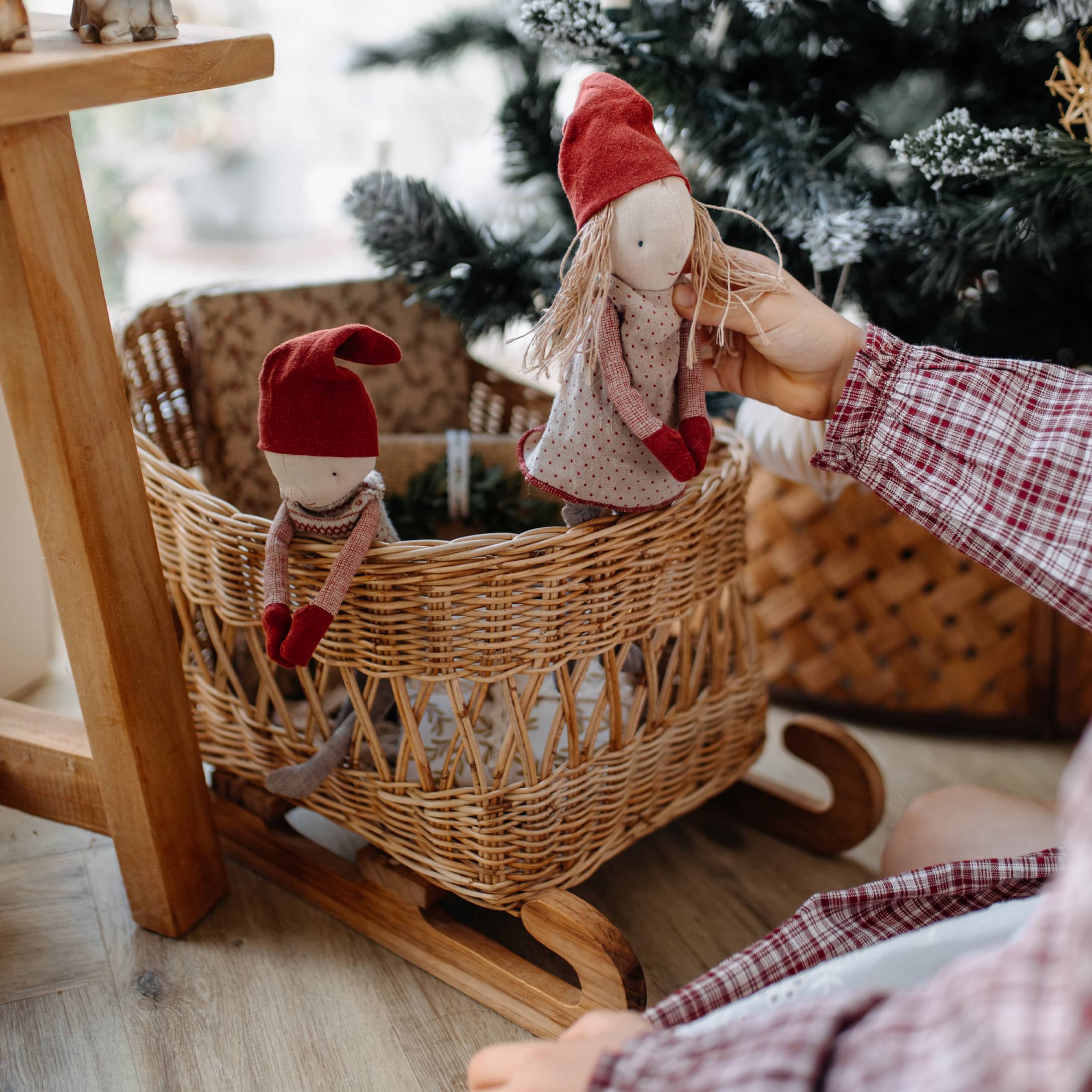 Berceau en bois avec panier en osier et deux poupées aux bonnets rouges, décoration de Noël