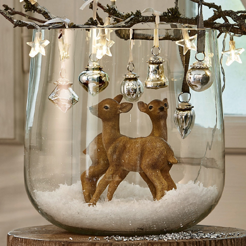 Décoration en verre avec deux faons marron et suspensions étoiles et cloches argentées