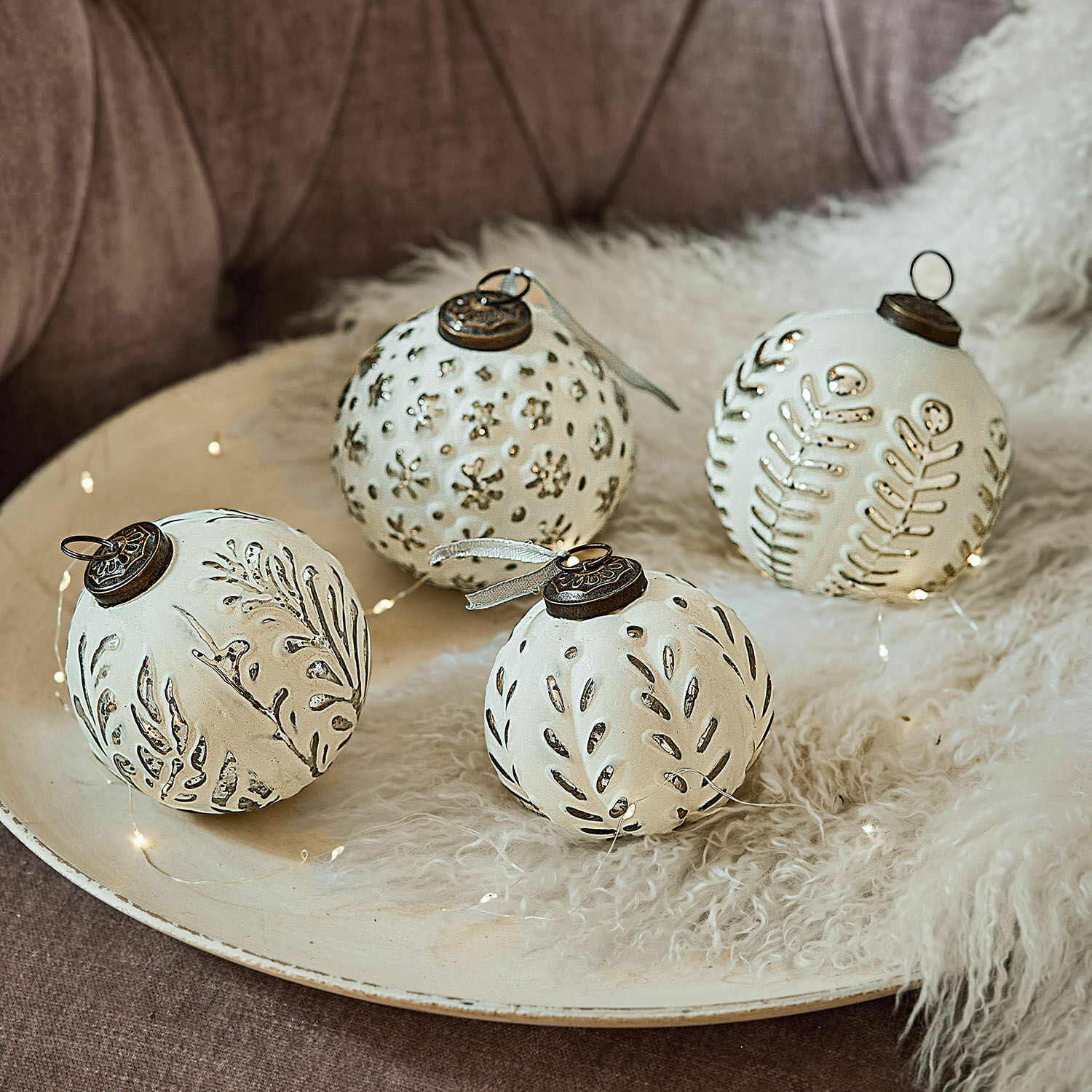 Lot de 4 boules de Noël Consac Ensemble de quatre boules de Noël blanches en céramique avec motifs végétaux et attaches métalliques
