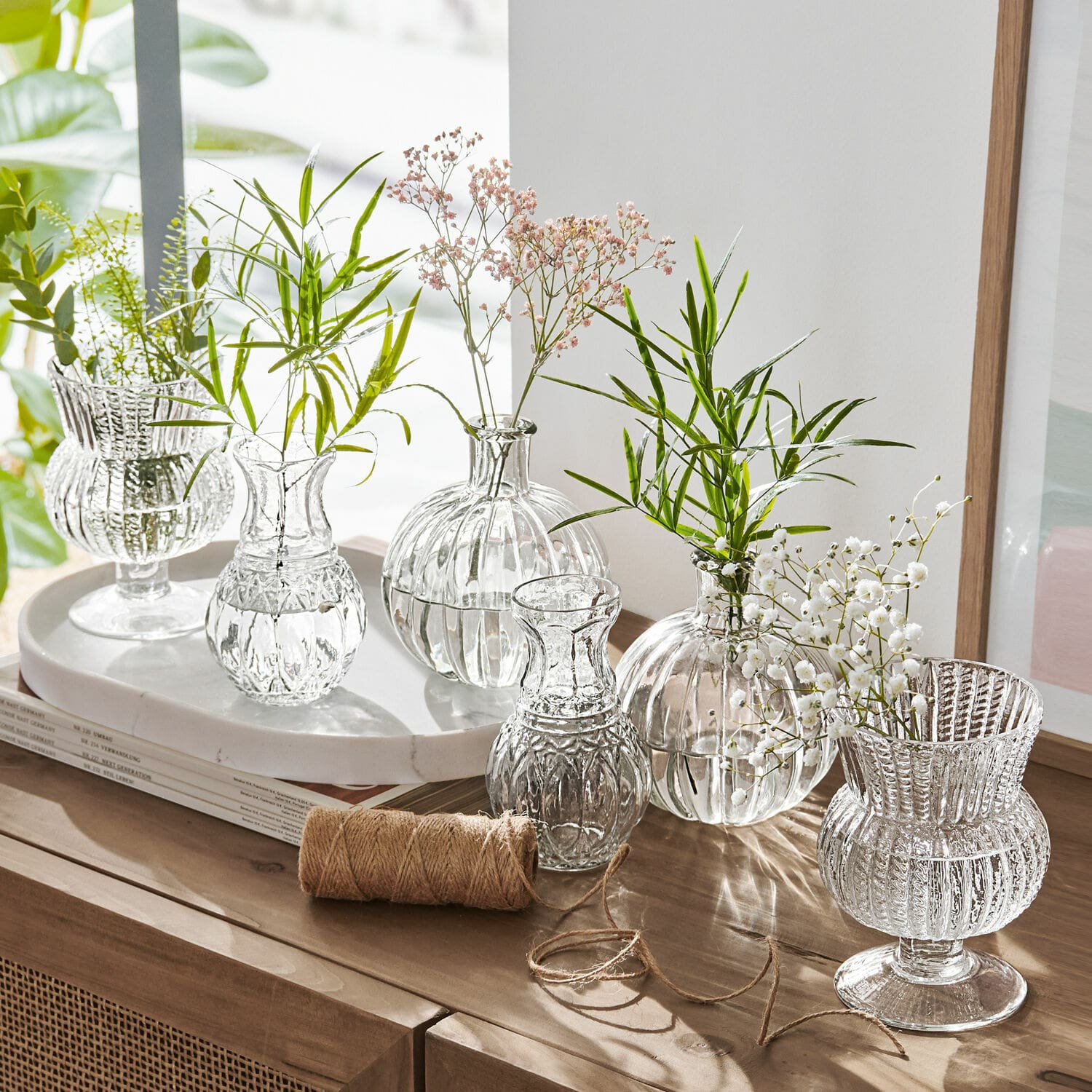 Lot de 6 vases Amber Ensemble de vases en verre transparent avec fleurs vertes et blanches sur un meuble en bois