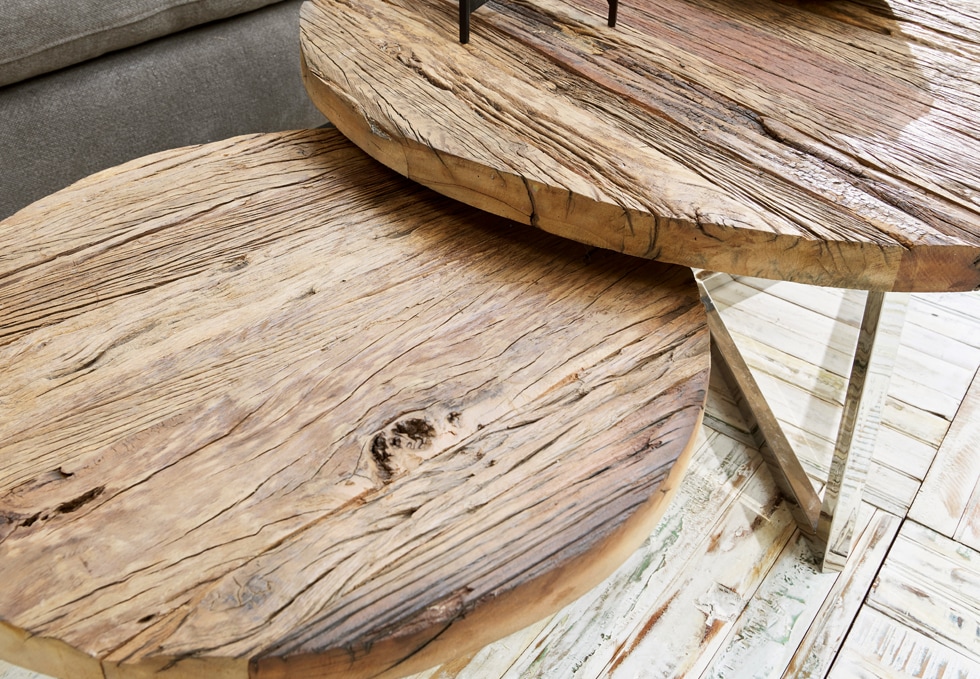 Deux tables rondes en bois naturel avec texture visible et pieds métalliques dans un style industriel