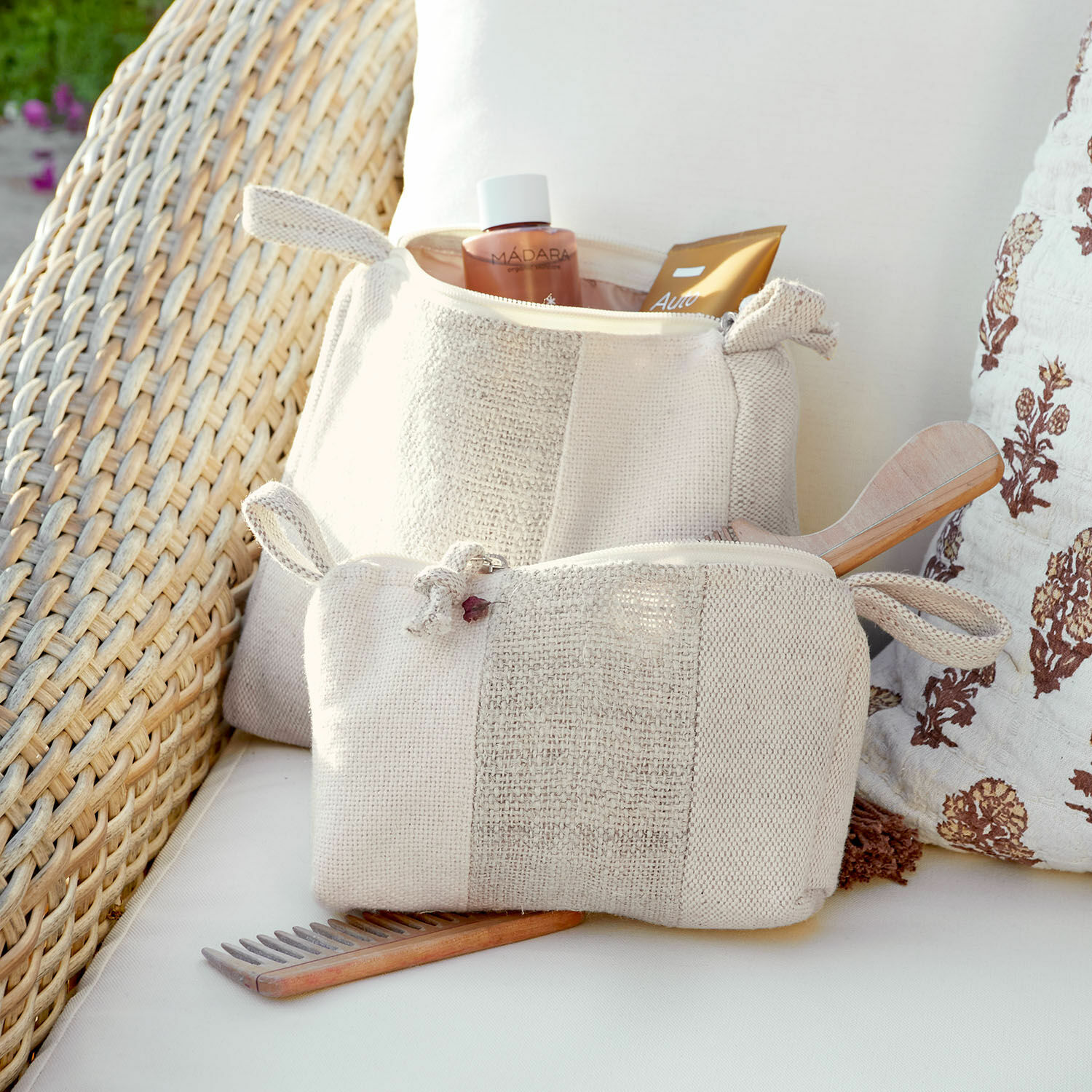 Lot de 2 trousses de toilette Xerivon Trousse de toilette beige en tissu avec peigne en bois et produits de soin sur canapé, accessoires beauté