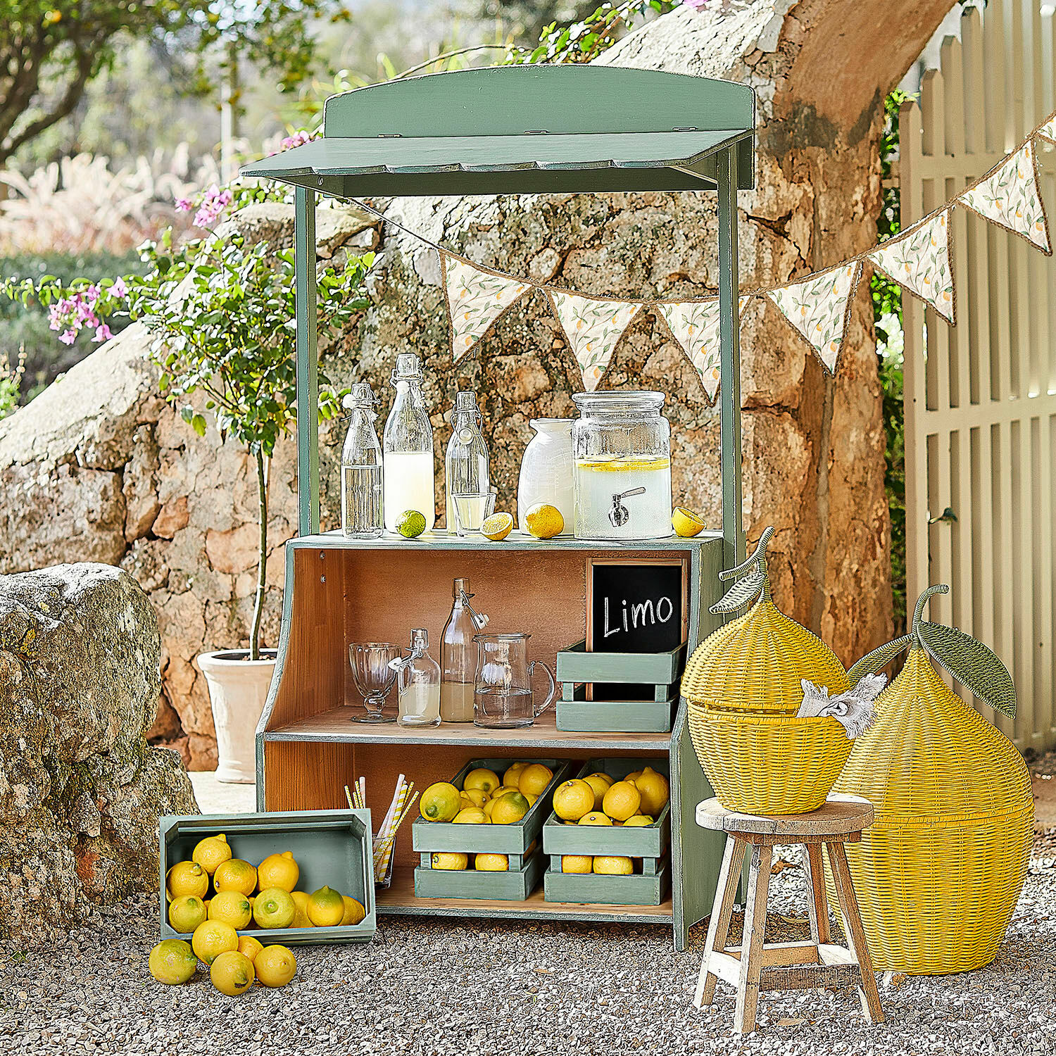 Stand de limonade Éclairon Étagère en bois verte avec citrons et bouteilles en verre pour limonade dans un jardin