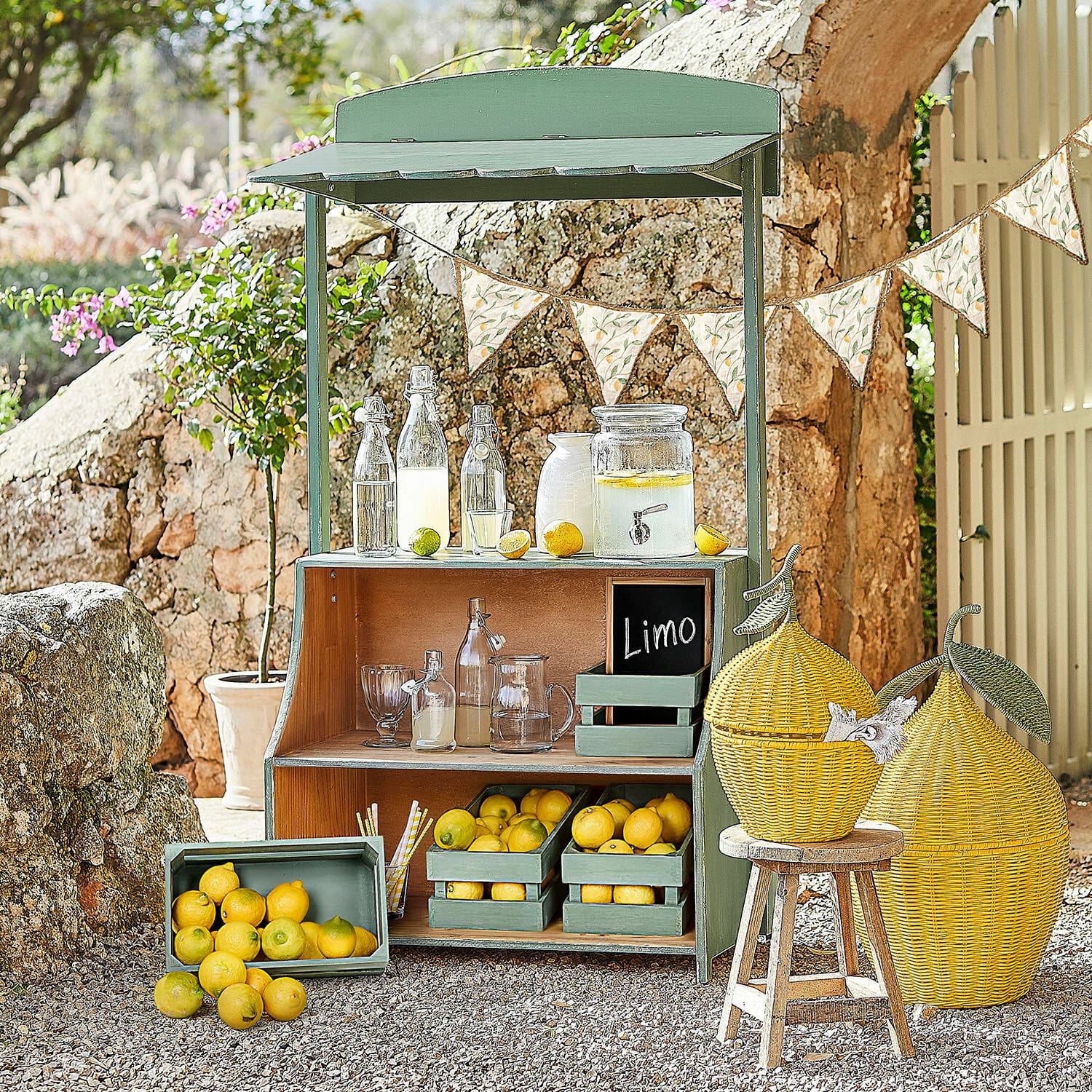 Stand de limonade Éclairon Étagère en bois verte avec citrons et bouteilles en verre pour limonade dans un jardin