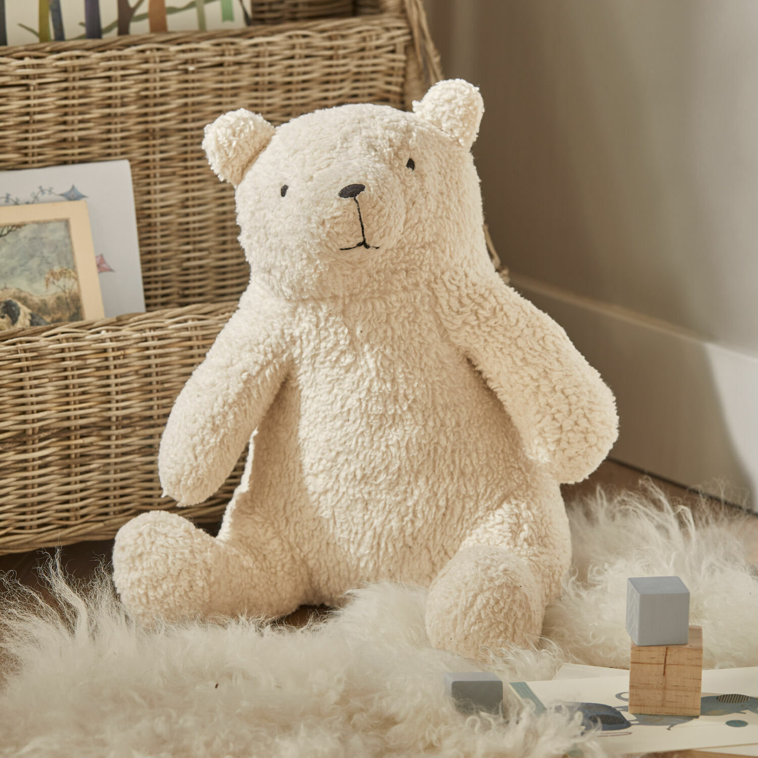 Peluche Hugo Peluche ours doux crème sur tapis en matières naturelles, décoration pour chambre d'enfant