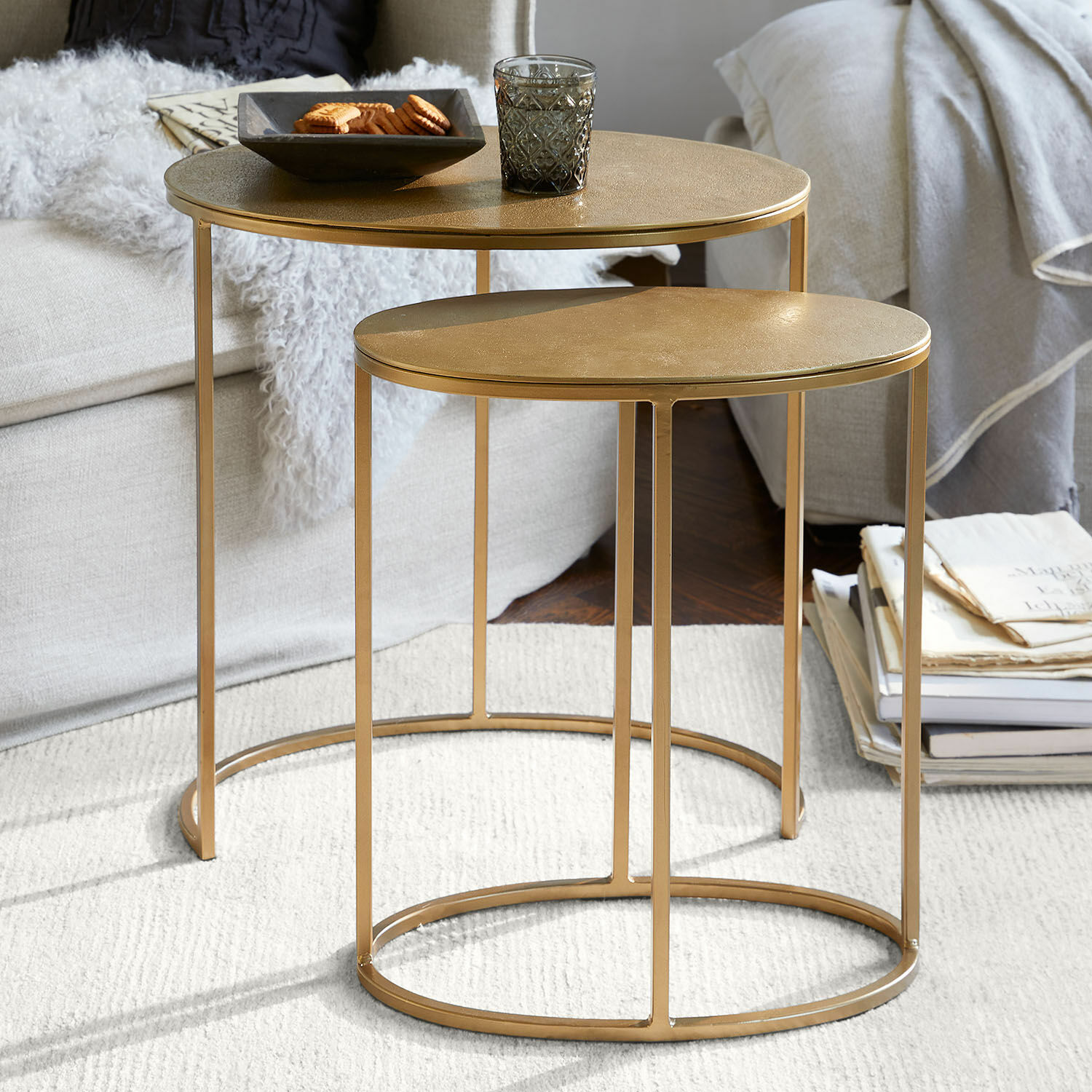 Lot de 2 tables d’appoint Leron Ensemble de deux tables basses rondes en métal doré sur tapis clair dans un salon cosy