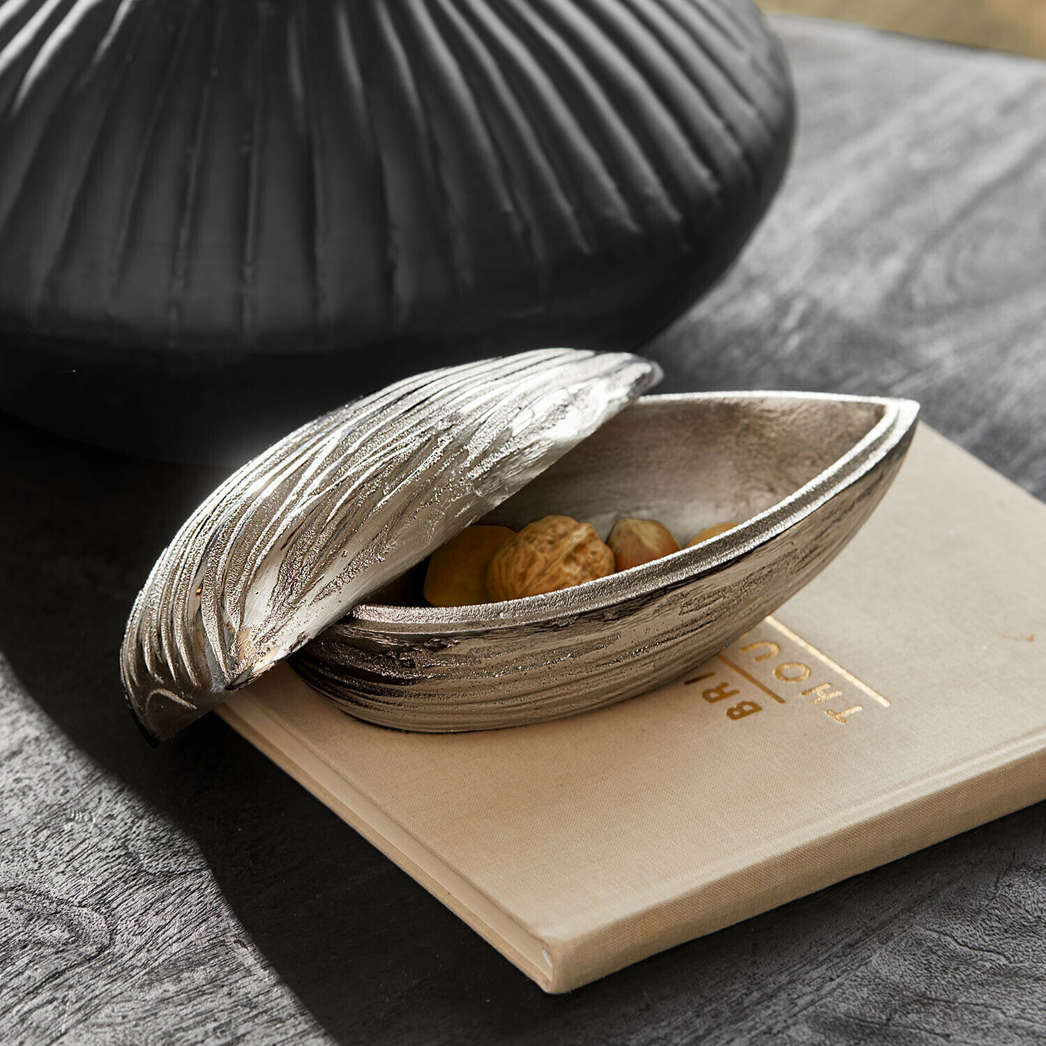 Objet décoratif Swansea Boîte décorative en métal argenté avec texture bois contenant des noix sur une table