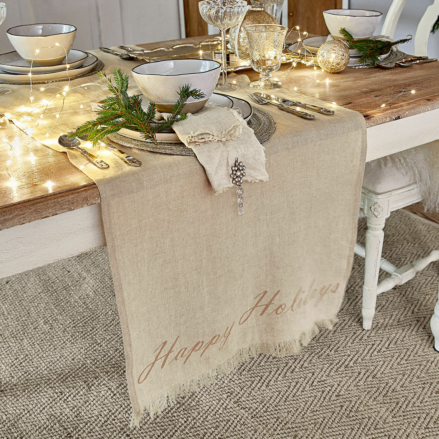 Chemin de table Emilia Chemin de table en lin beige sur table en bois avec décoration de Noël et vaisselle