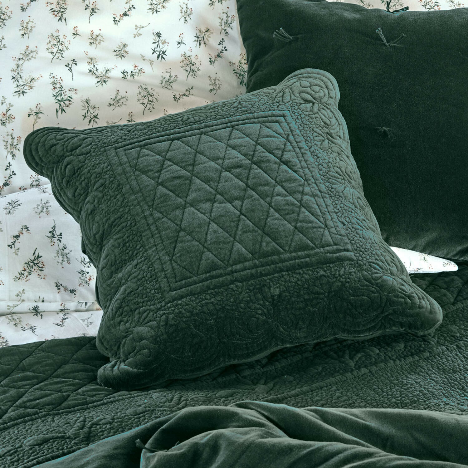 Housse de coussin Lunévois Coussin vert en velours avec motif matelassé sur lit avec housse de couette fleurie et plaid