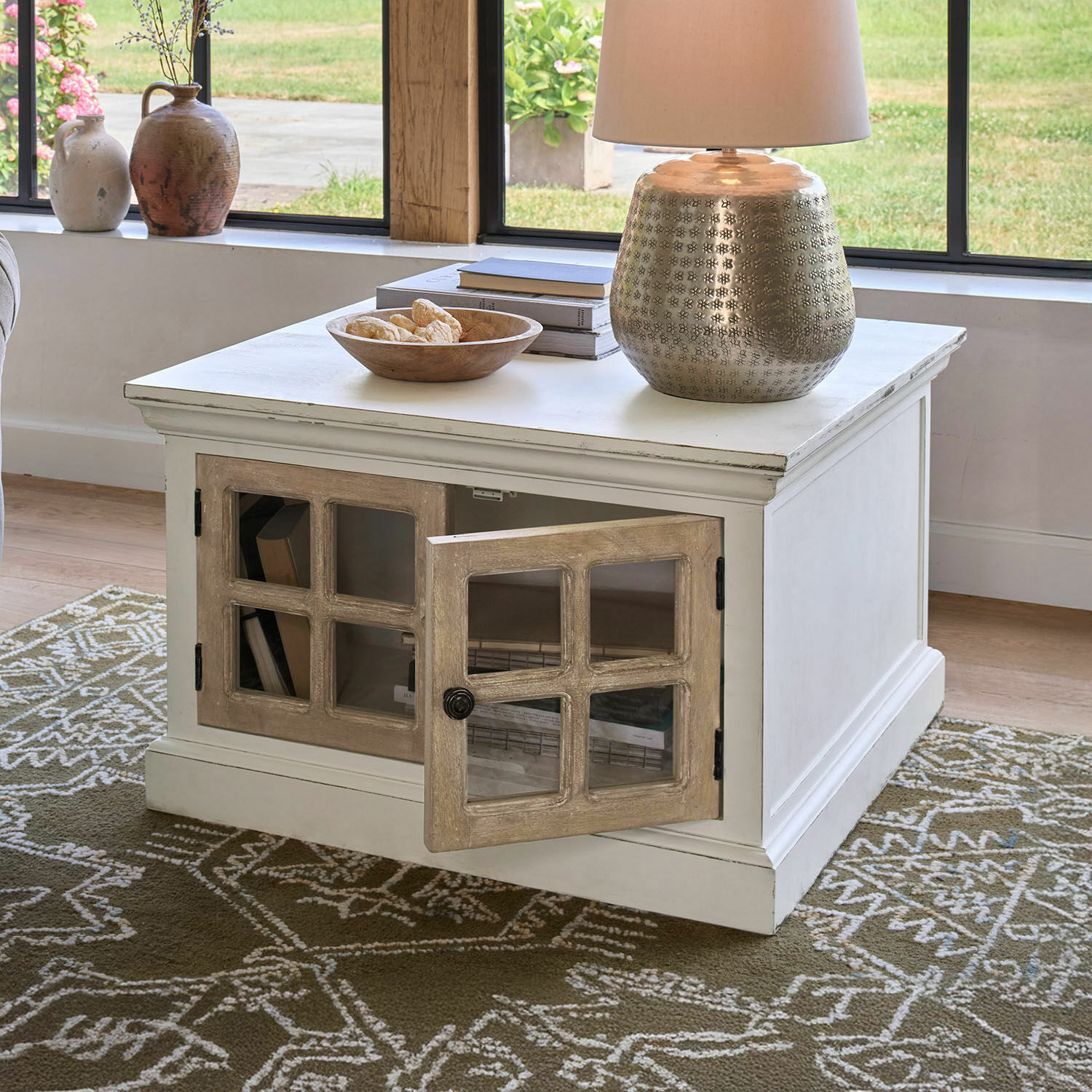 Table basse Marshwood Table basse blanche en bois avec porte vitrée et lampe décorative sur tapis vert à motifs