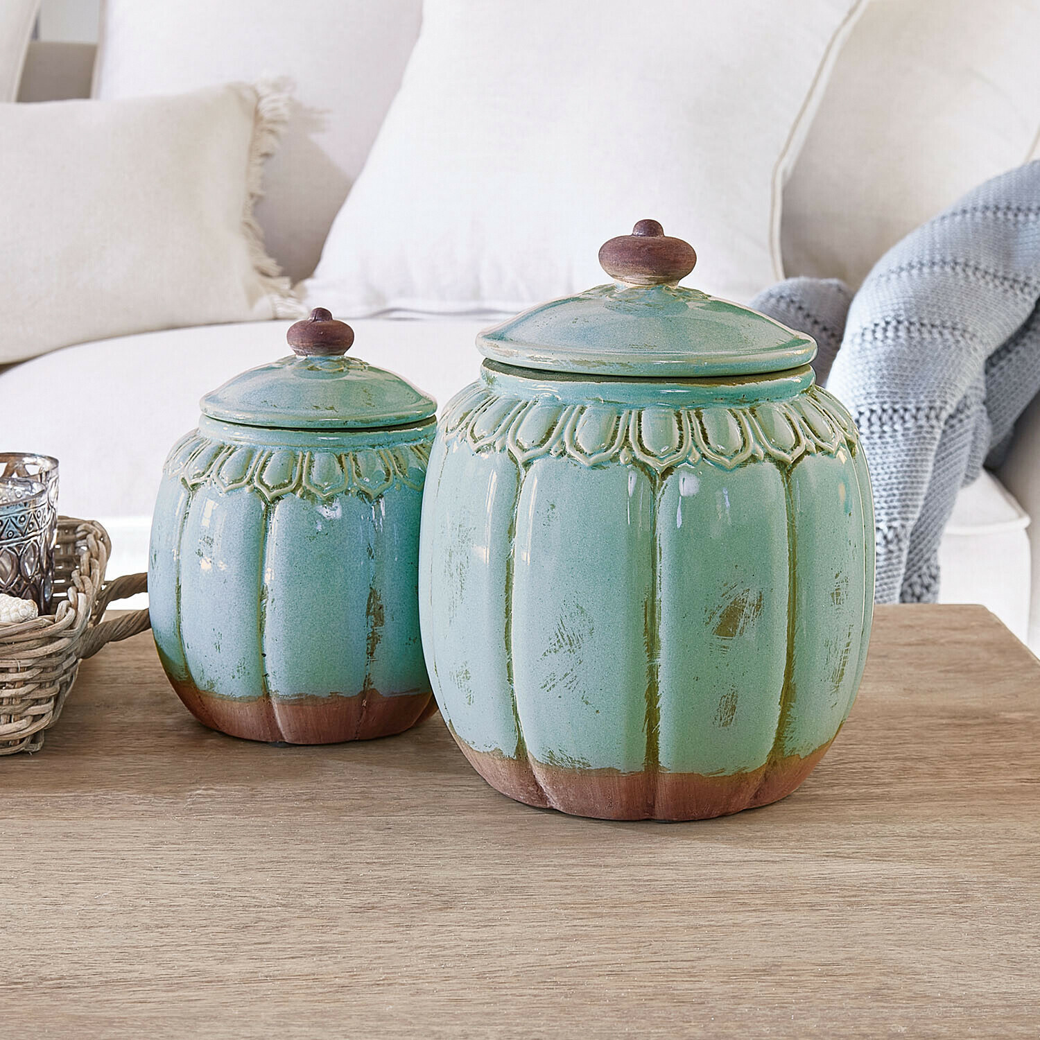 Ensemble de deux pots en céramique verts avec détails marron posés sur une table en bois