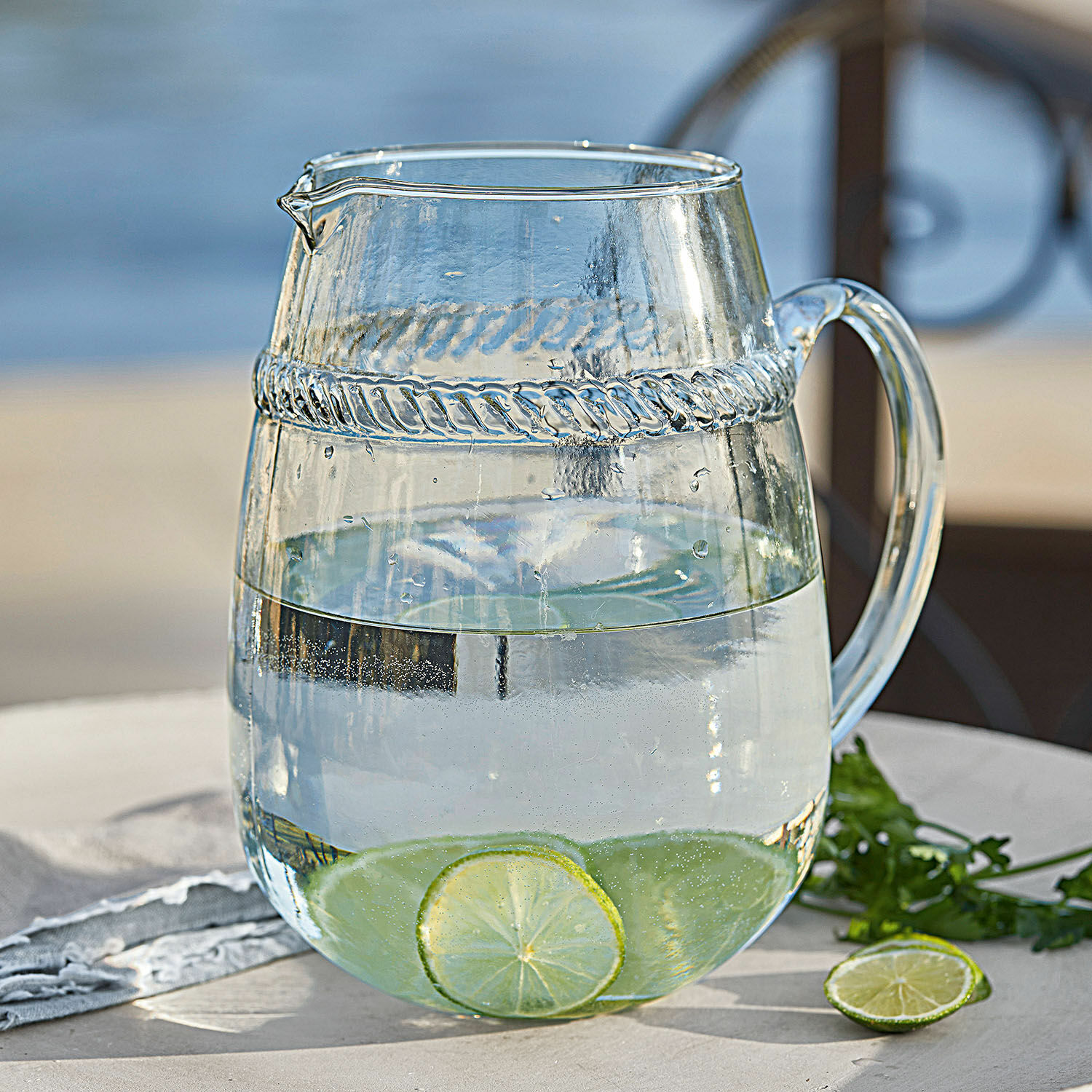 Carafe Beiras Carafe en verre transparent avec eau et tranches de citron vert sur une table extérieure