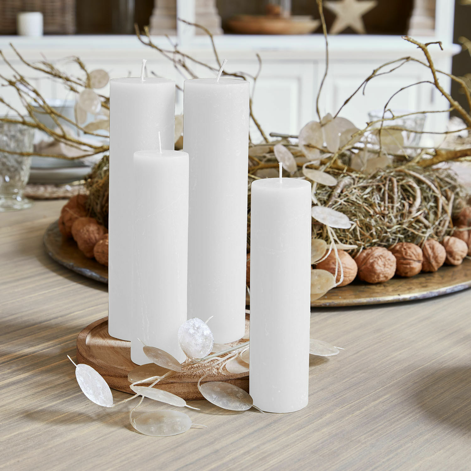 Lot de 4 bougies Avinal Ensemble de quatre bougies blanches décoratives sur un plateau en bois avec éléments naturels