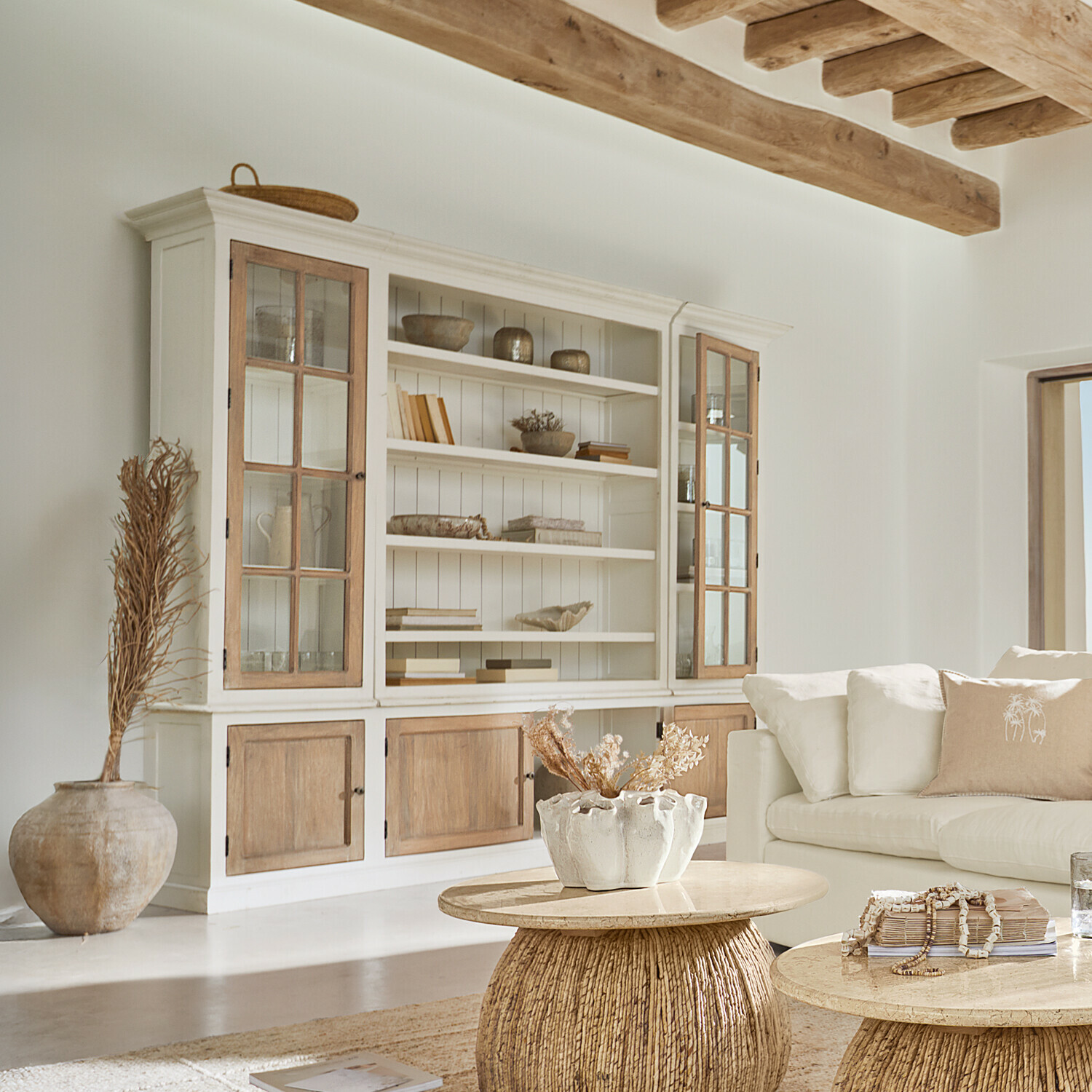Vitrine Springford Buffet en bois clair avec portes vitrées et décorations naturelles dans un salon lumineux