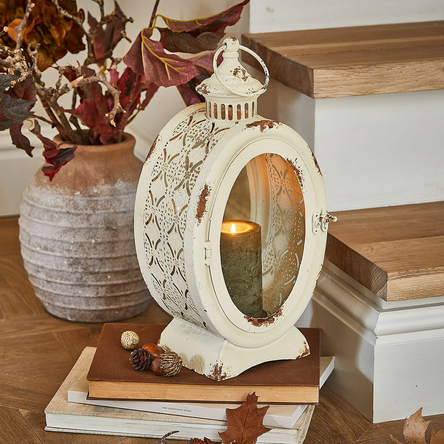 Lanterne Sublimelle Lanterne en métal vintage crème avec bougie allumée et décorations d'automne sur livres