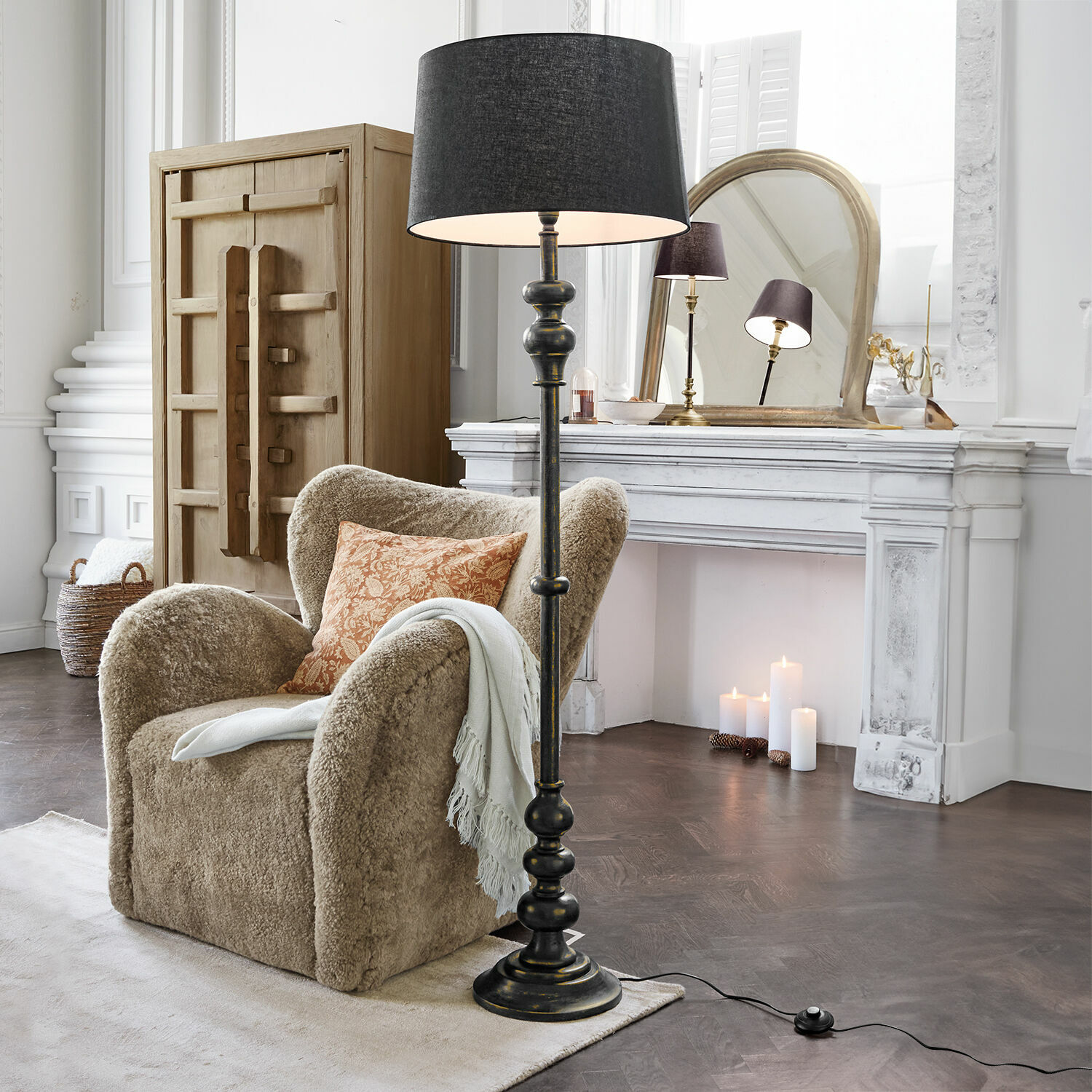 Lampadaire Reville Lampadaire noir avec abat-jour dans un salon classique avec fauteuil beige et cheminée blanche