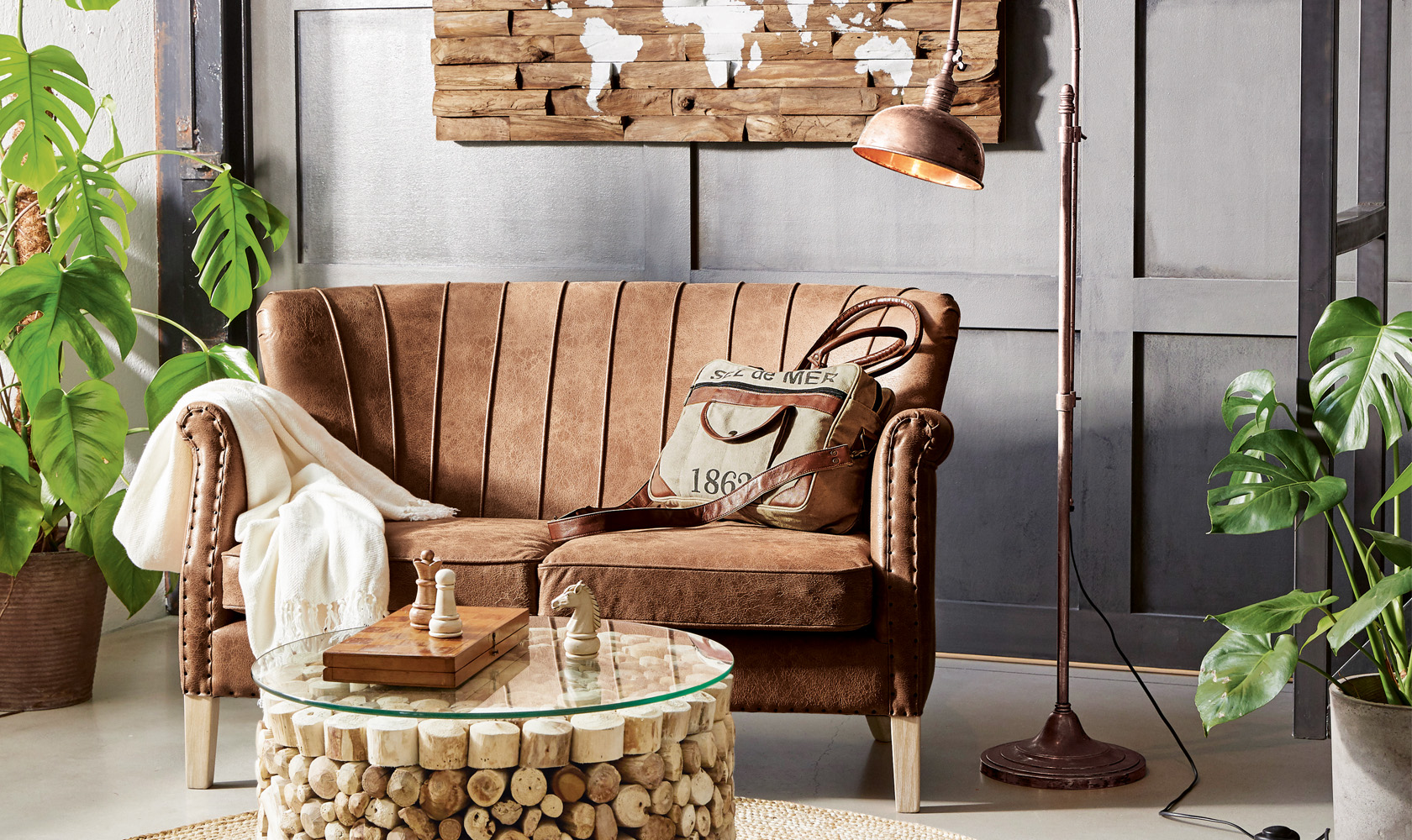 Canapé vintage en cuir marron avec plaid crème et table basse en bois avec jeu d'échecs dans un salon
