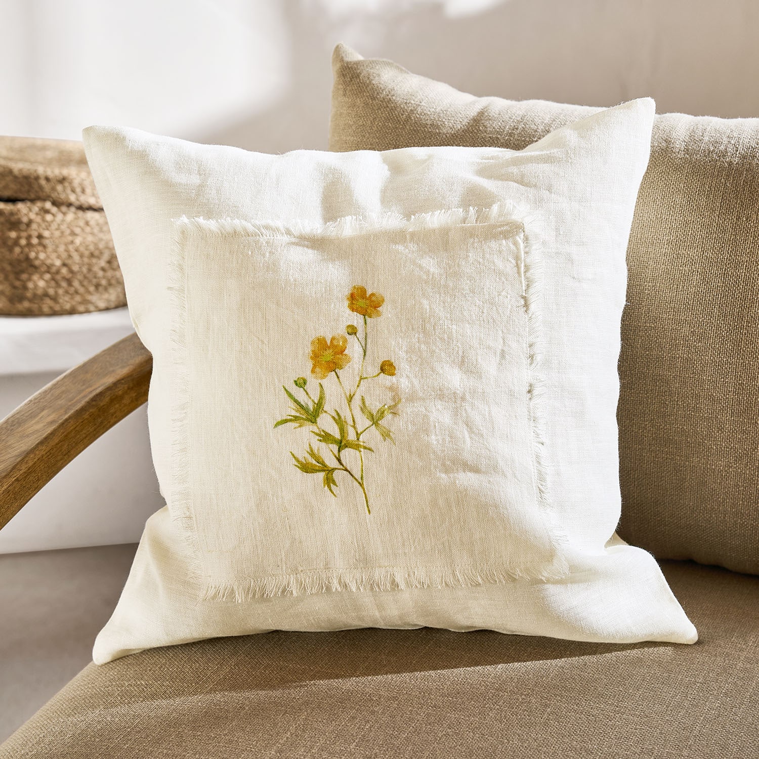 Coussin décoratif en lin crème avec motif floral jaune et bords effilochés pour salon cosy