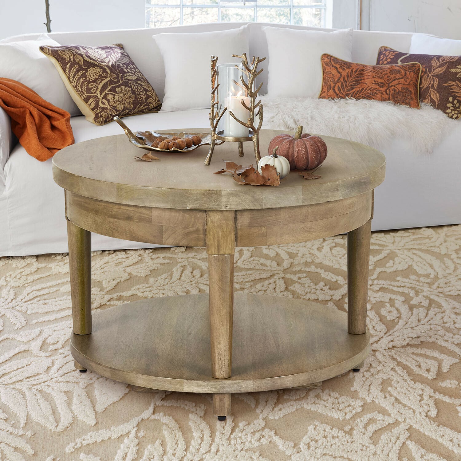Table basse Talinar Table basse ronde en bois couleur naturelle avec décoration de bougie et citrouilles sur tapis beige