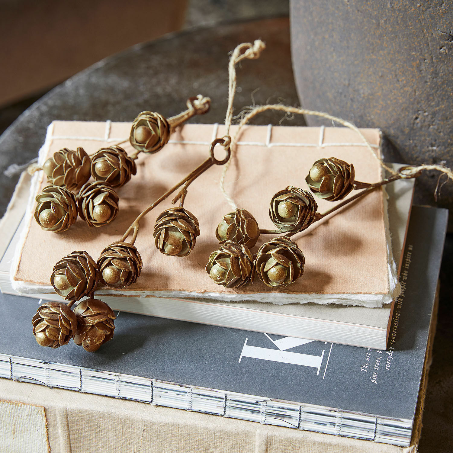 Lot de 3 décorations à suspendre Lazimra Branches décoratives avec pommes de pin brunes posées sur une pile de livres, décoration naturelle