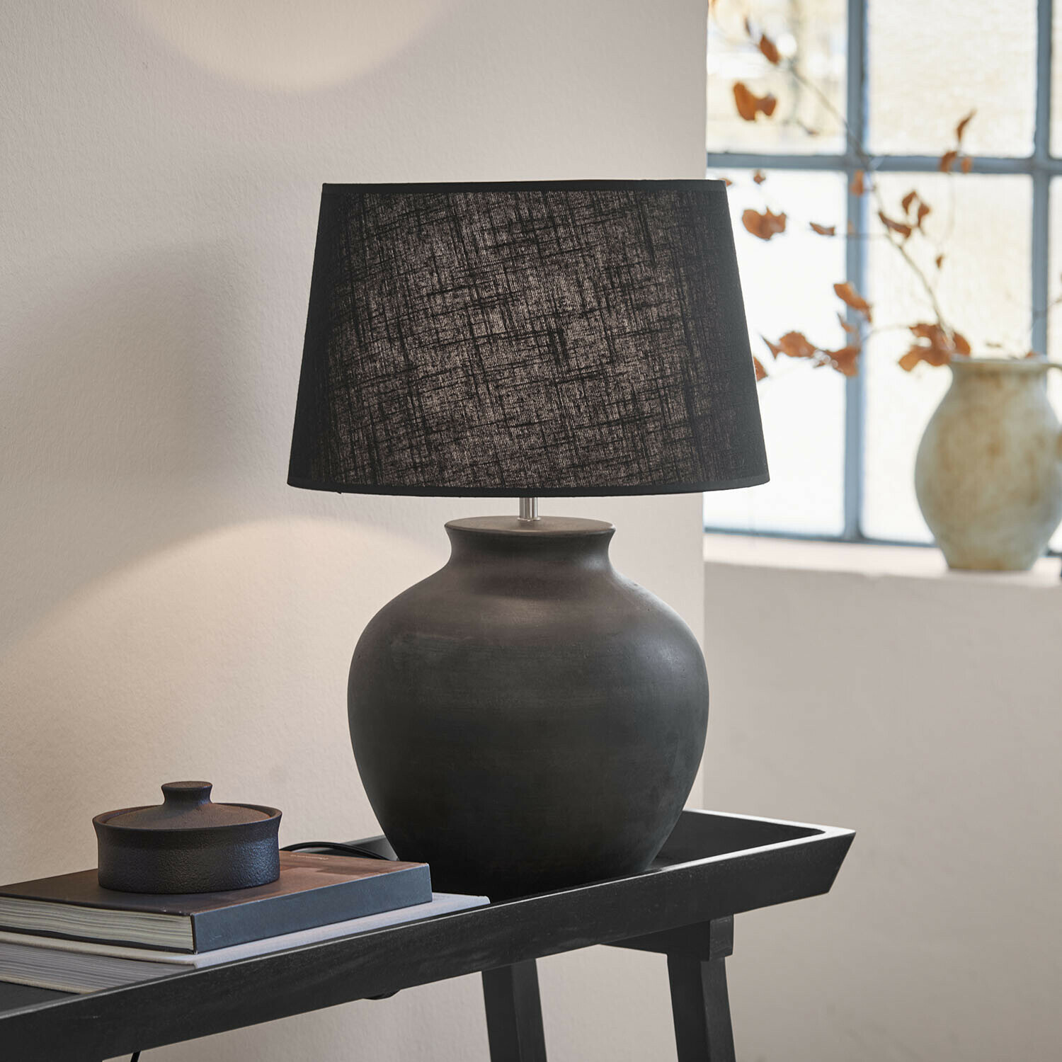 Lampe à poser Branver Lampe de table en céramique noire avec abat-jour en tissu sur une table avec livres et décoration