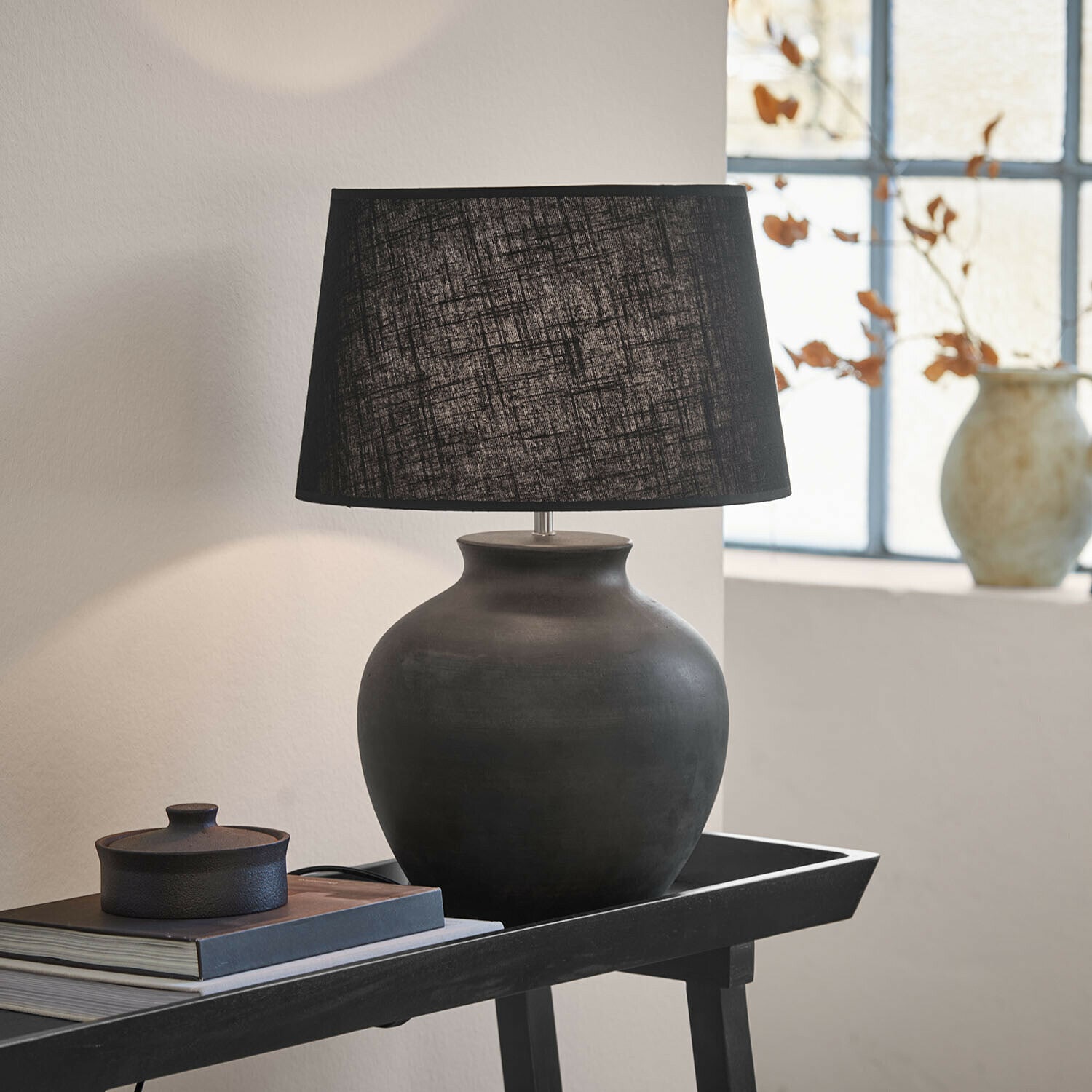 Lampe à poser Branver Lampe de table en céramique noire avec abat-jour en tissu sur une table avec livres et décoration