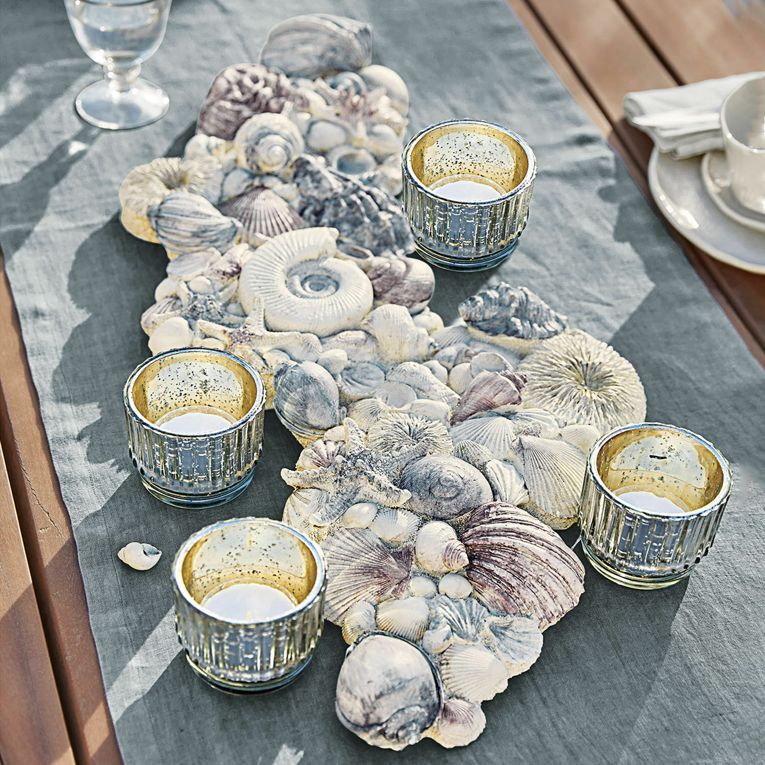 Coquillages décoratifs Potnarvin Chemin de table décoratif avec coquillages et quatre photophores en verre sur table en bois avec tissu