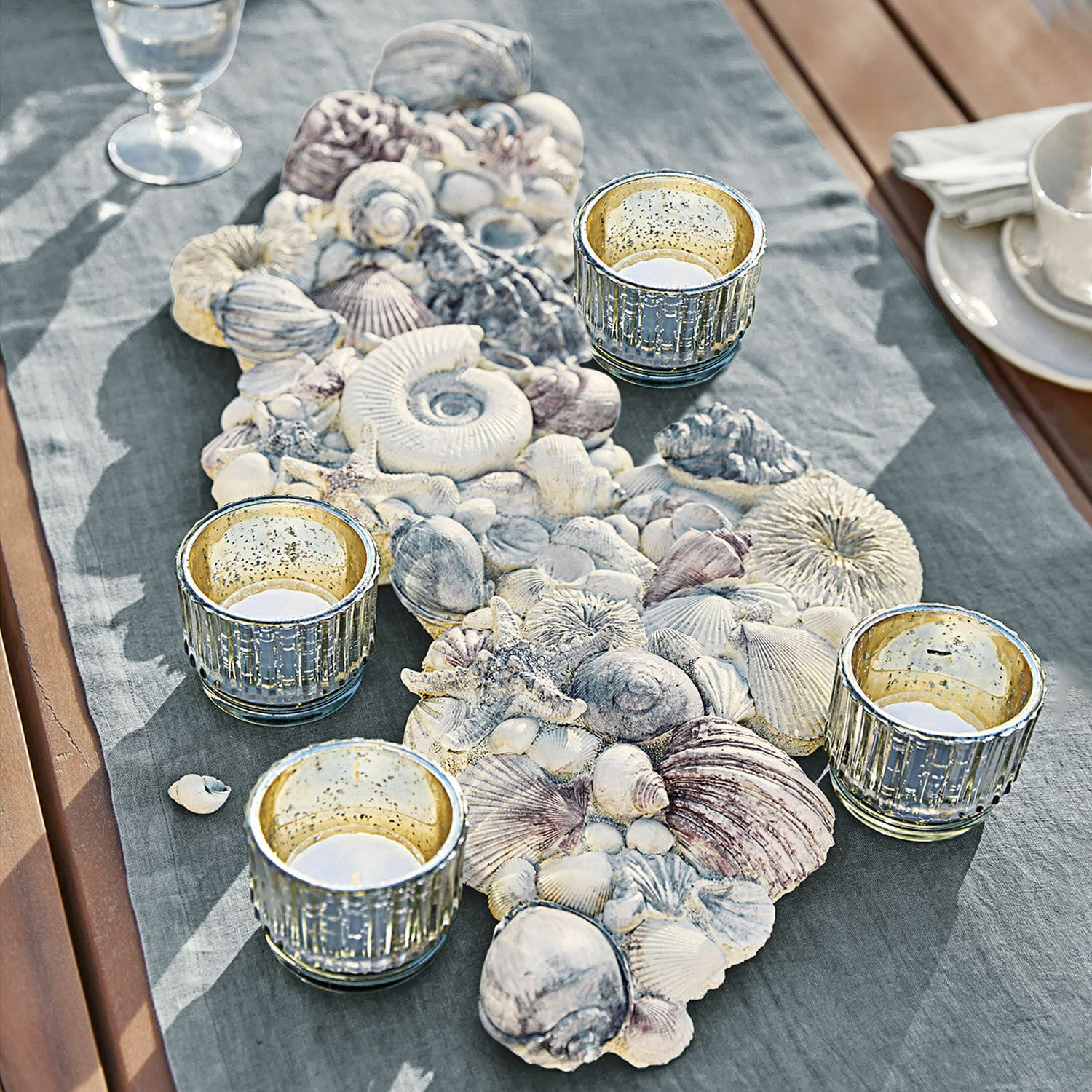 Coquillages décoratifs Potnarvin Chemin de table décoratif avec coquillages et quatre photophores en verre sur table en bois avec tissu