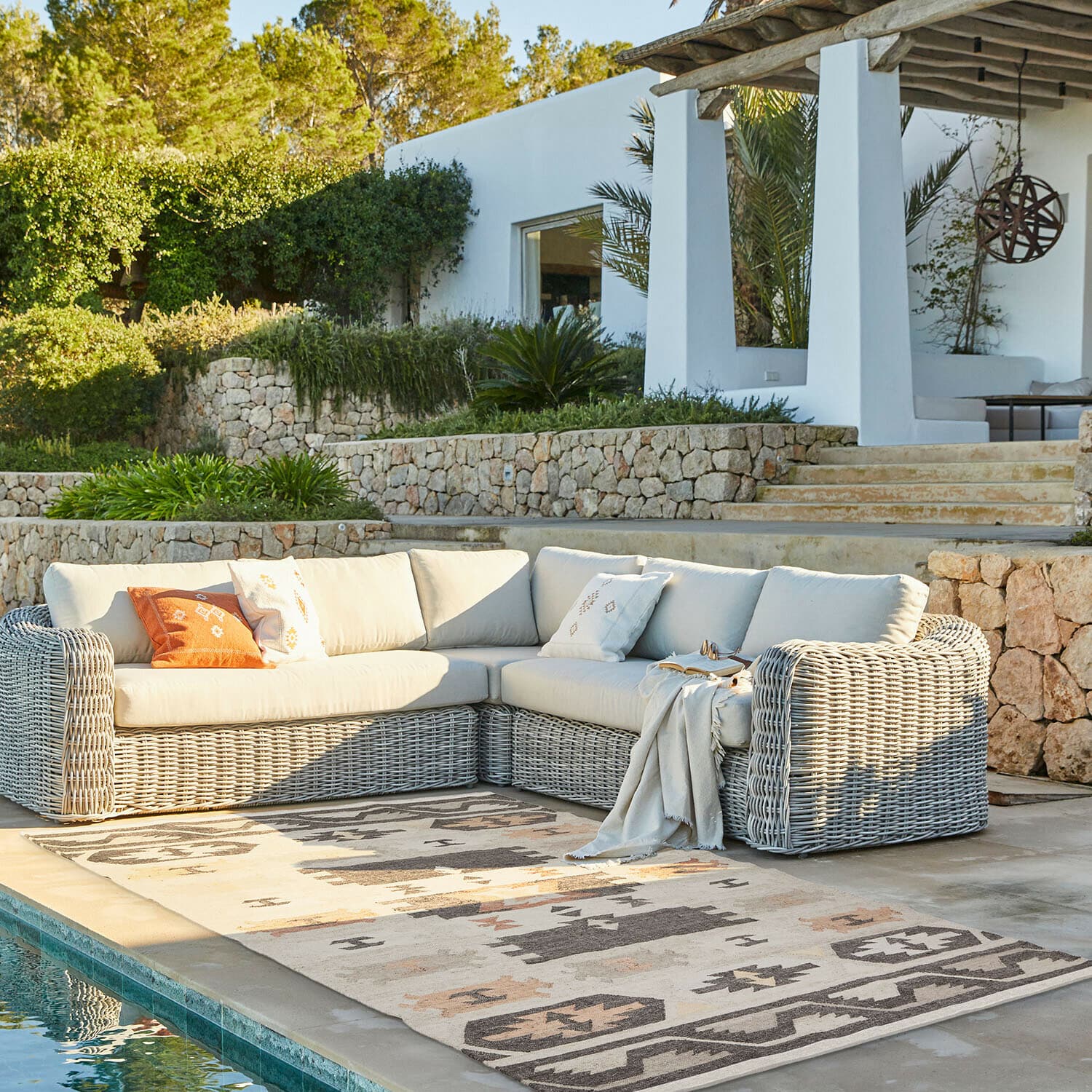 Tapis d’intérieur et d’extérieur Selamir Canapé d'angle d'extérieur en osier clair avec coussins crème sur terrasse au bord de la piscine