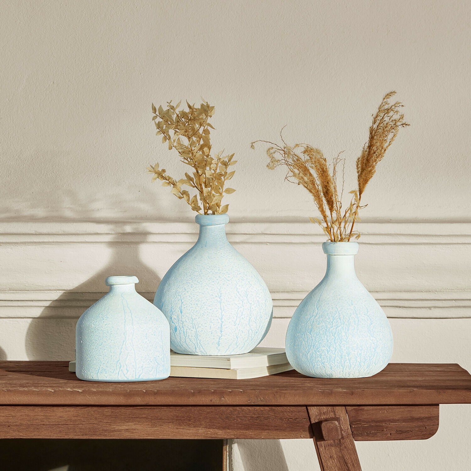 Lot de 3 vases Donara Ensemble de trois vases en céramique bleue avec plantes séchées sur une table en bois pour décoration intérieure