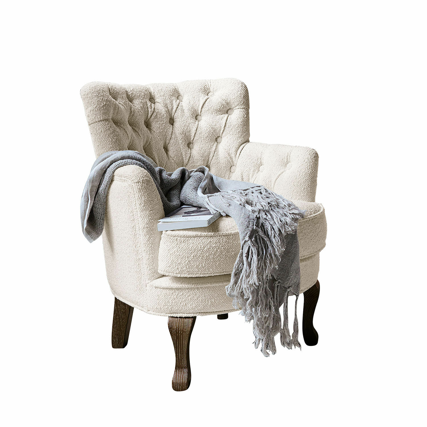 Fauteuil Calgary Fauteuil beige en tissu bouclé avec pieds en bois foncé, couverture grise et livre posé dessus