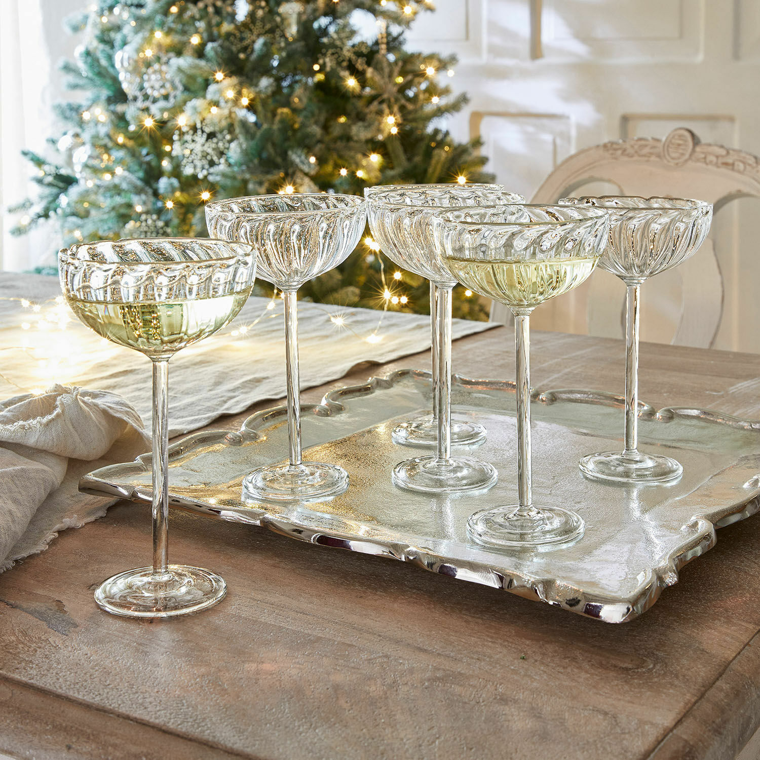 Lot de 6 verres Bavella Ensemble de six coupes à champagne en verre transparent sur un plateau argenté, décorations de Noël